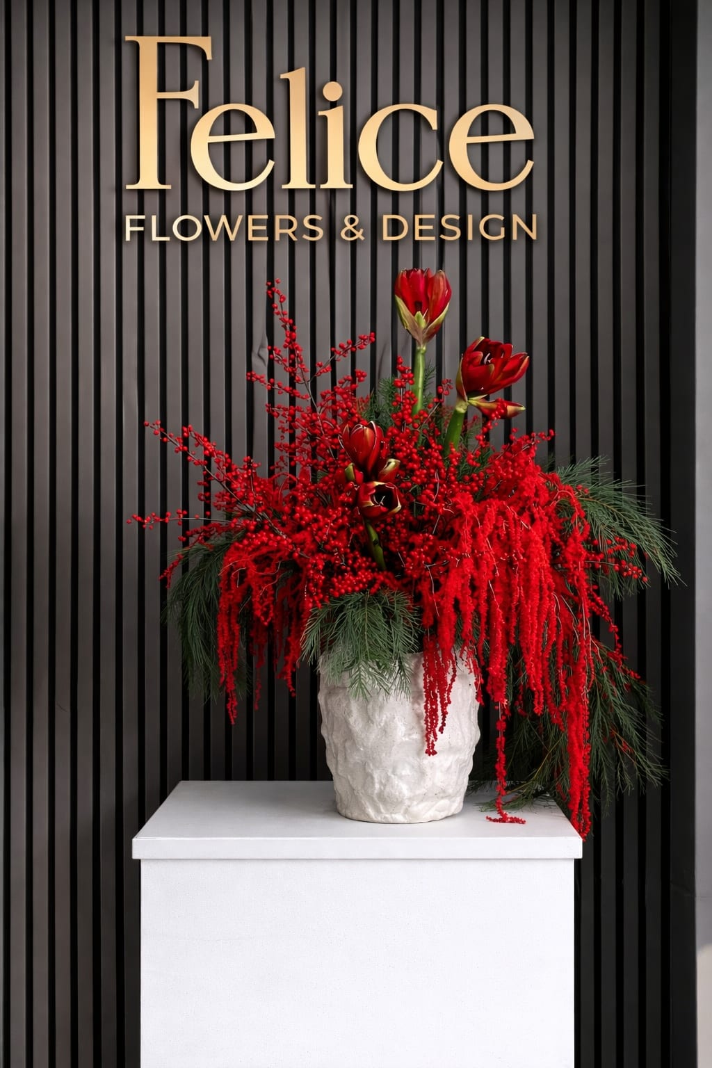 Red floral arrangement in a white textured vase
