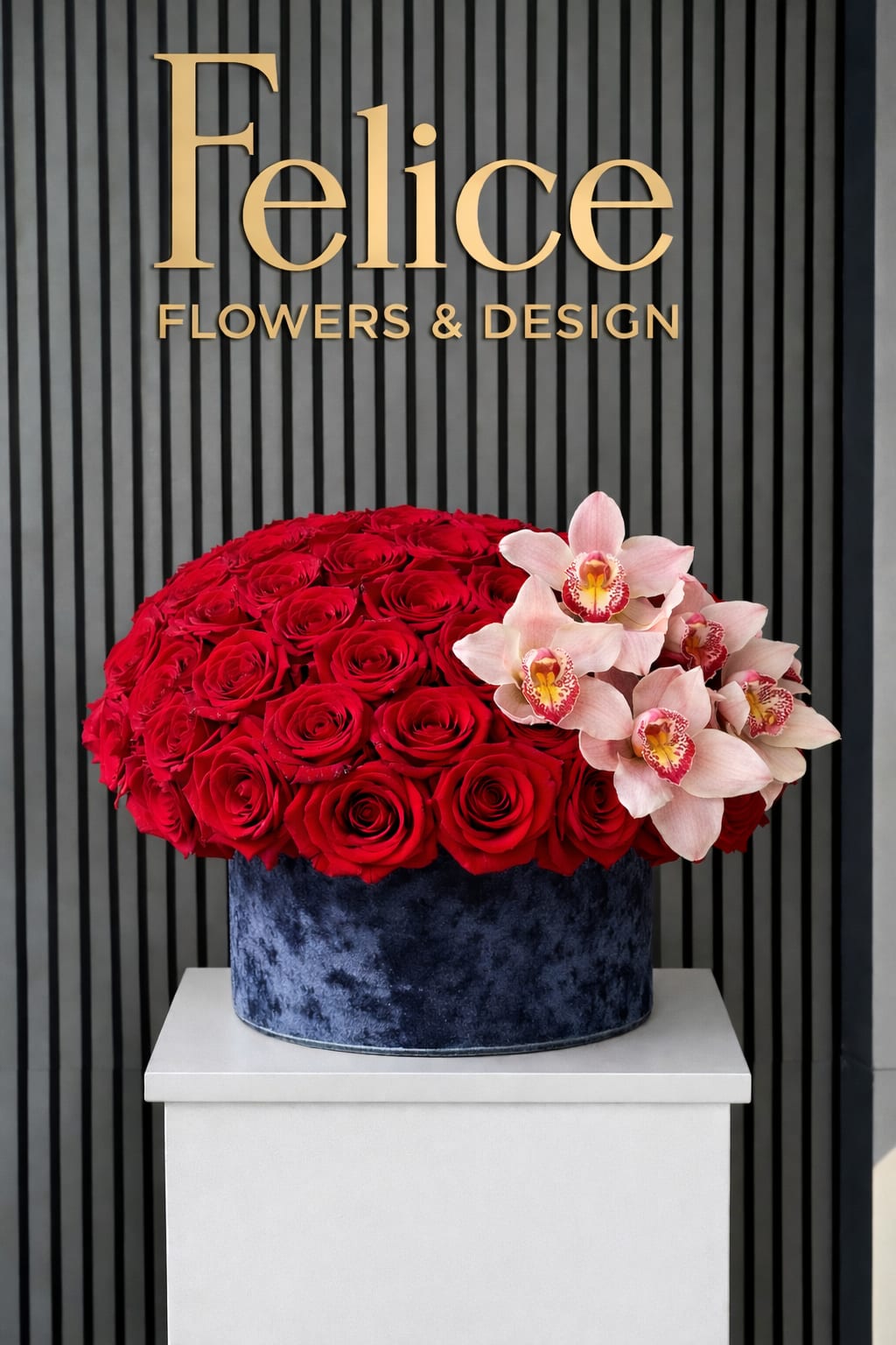 Red roses and pale pink orchids arranged in a blue velvet box