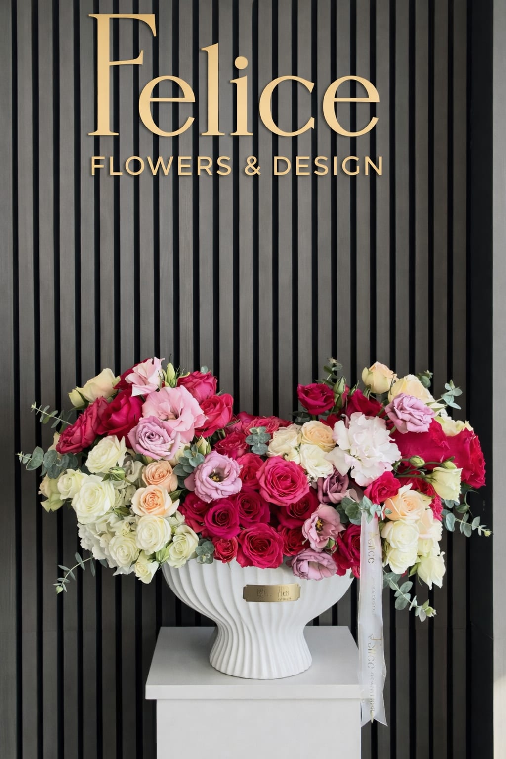 Large rose arrangement in a white pedestal vase