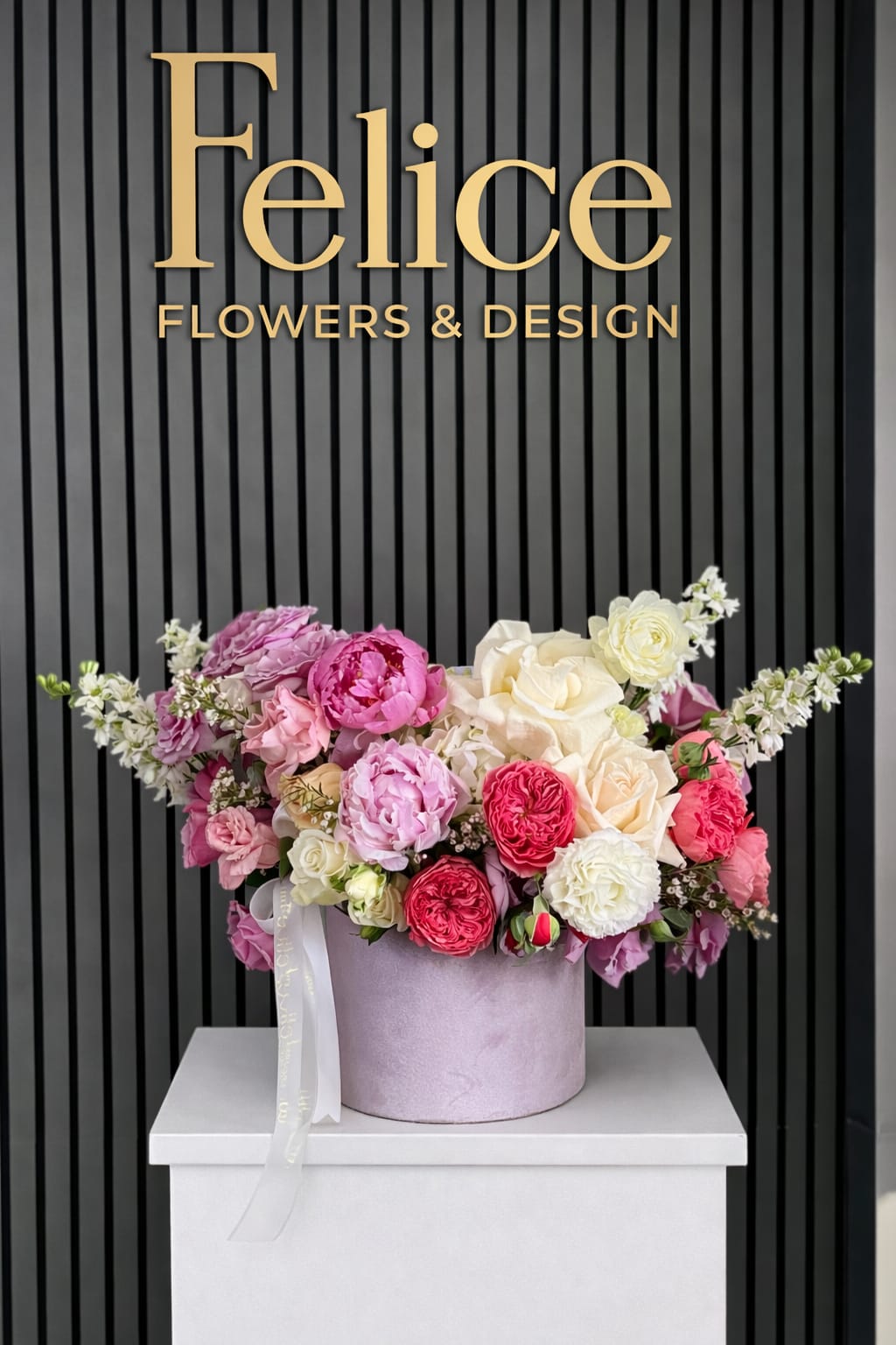 Pink, white, and cream roses arranged in a round lavender box