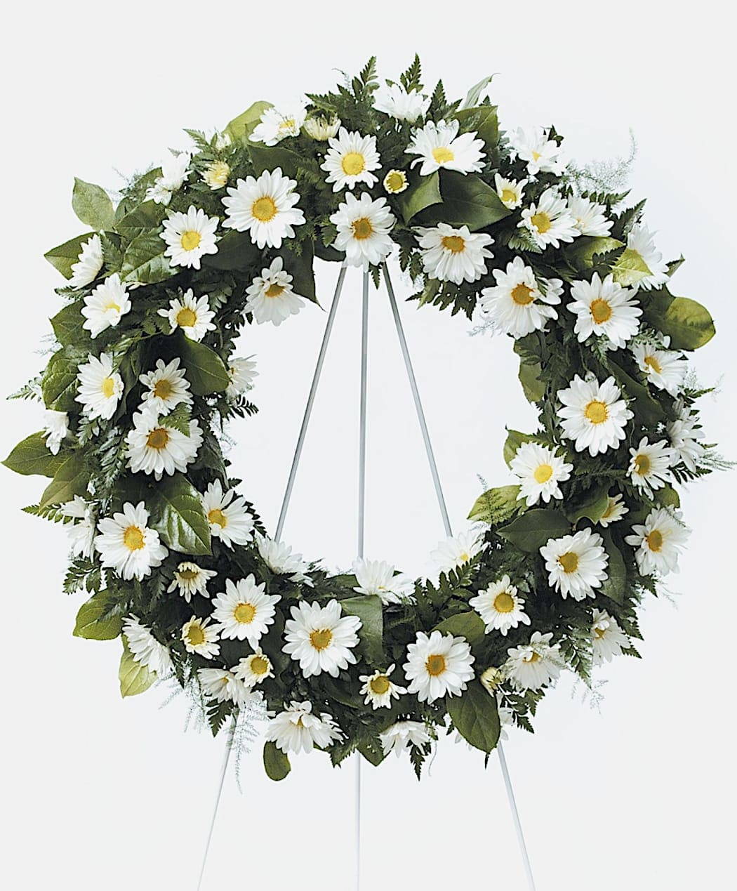 Standing wreath of white daisies with yellow centers on a metal easel