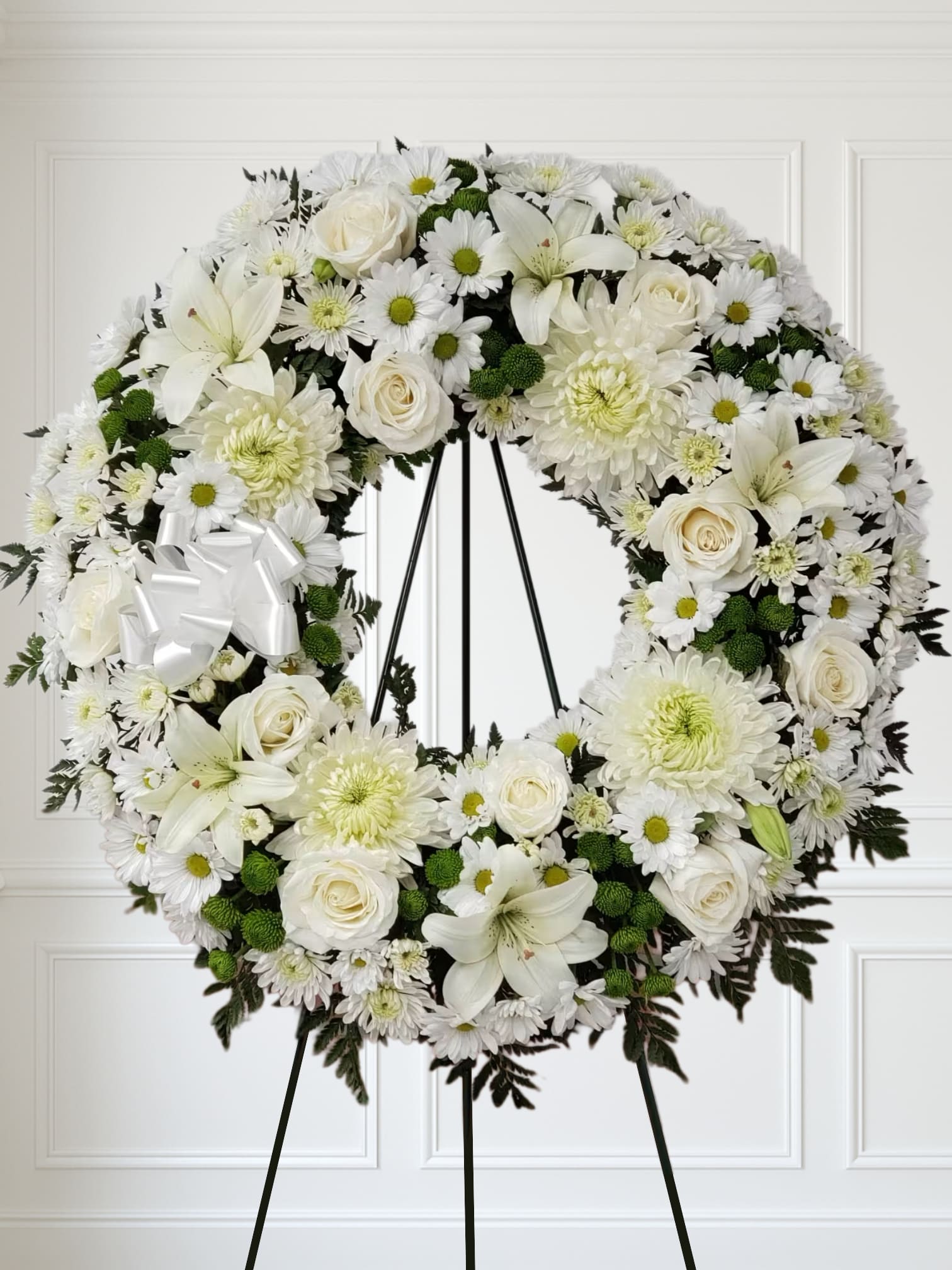 Lasting Serenity Wreath by Manny - A beautiful white and green tribute wreath that calms, this easel arrangement celebrates a full life and a peaceful passing. 