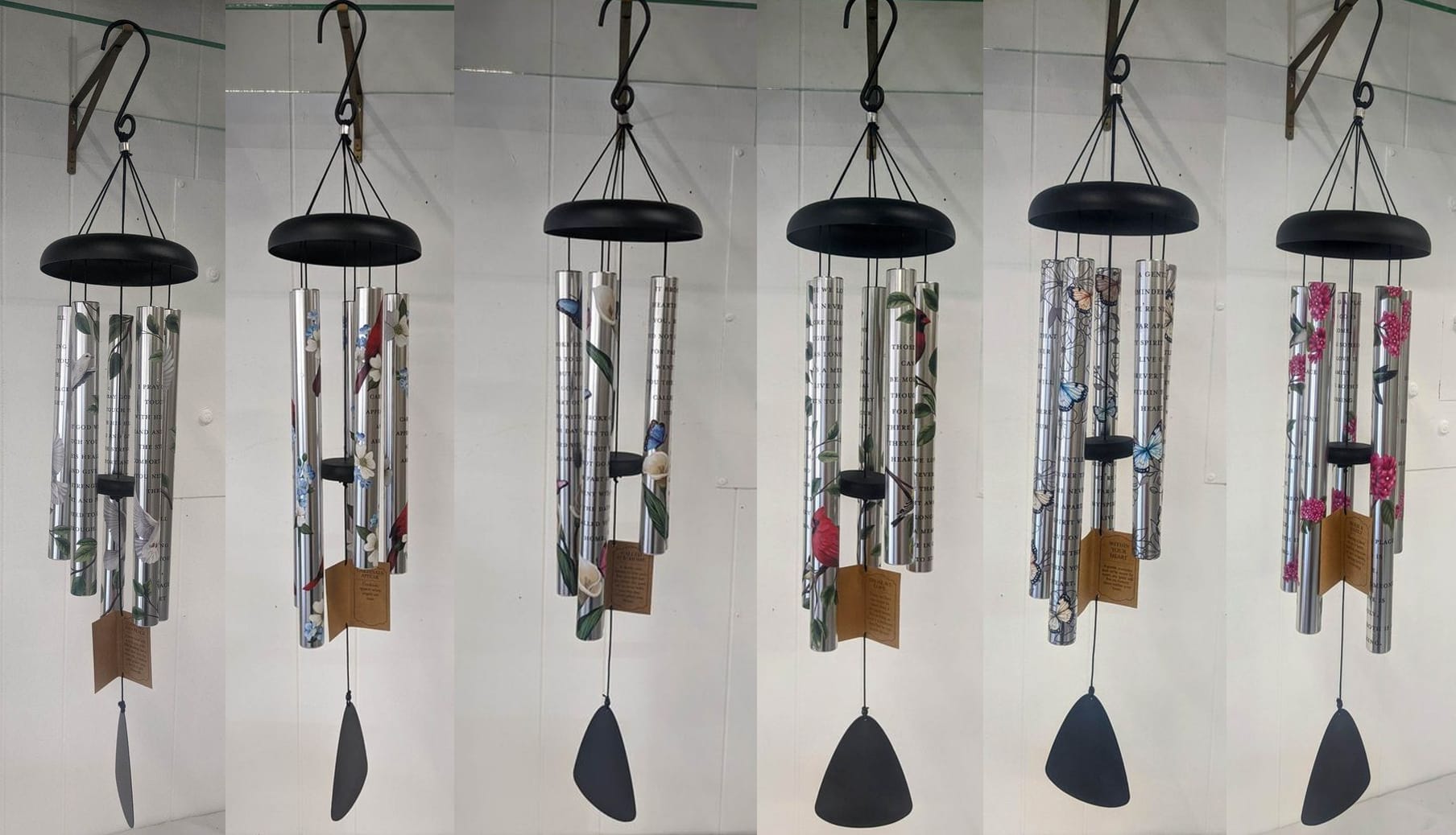Six hanging metal wind chimes with floral patterns and black tops