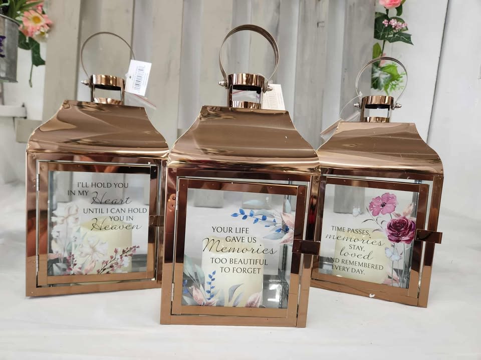 Three rose-gold lanterns with memorial quote inserts