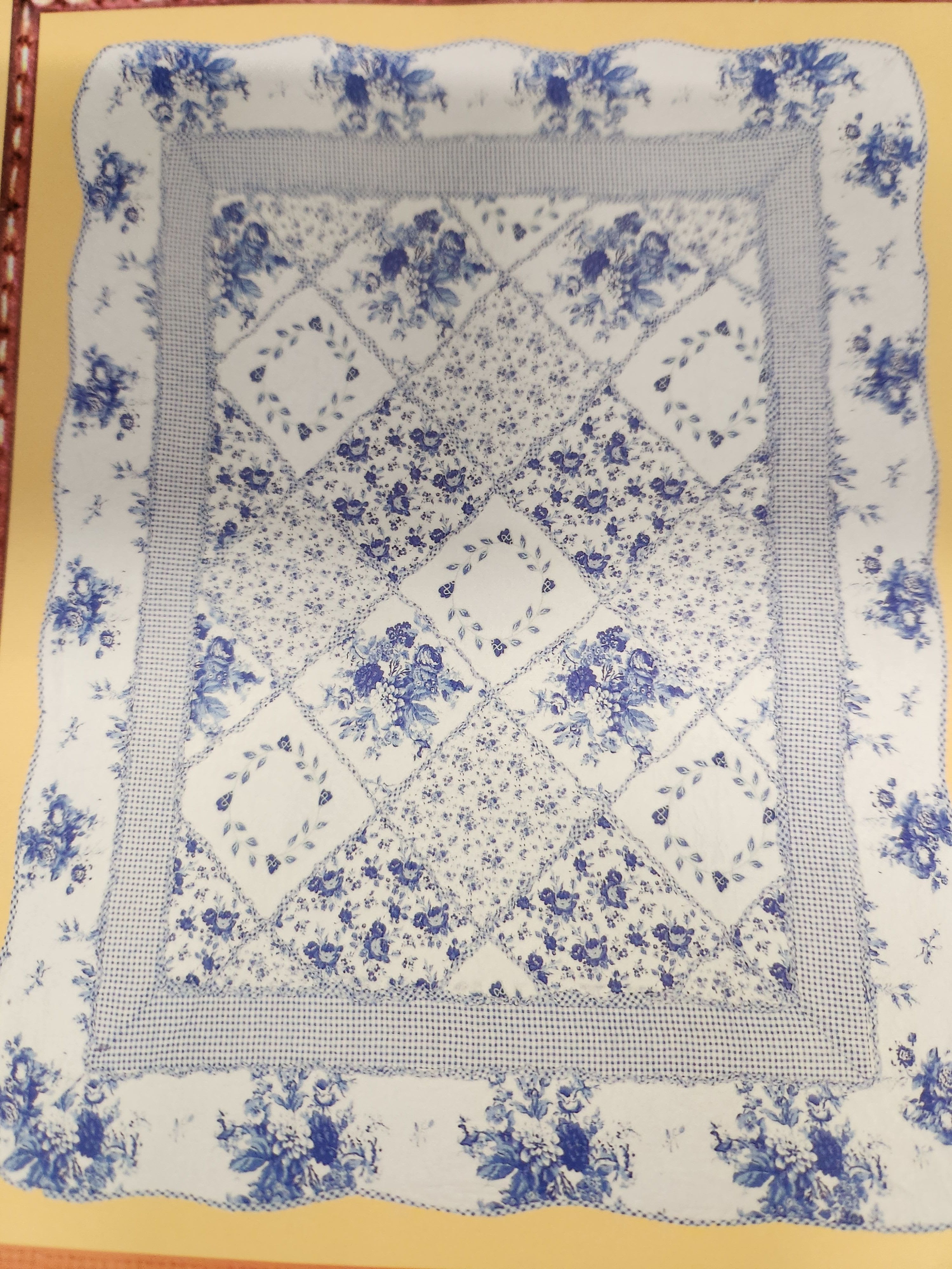 Blue-and-white floral quilt with patchwork diamond pattern