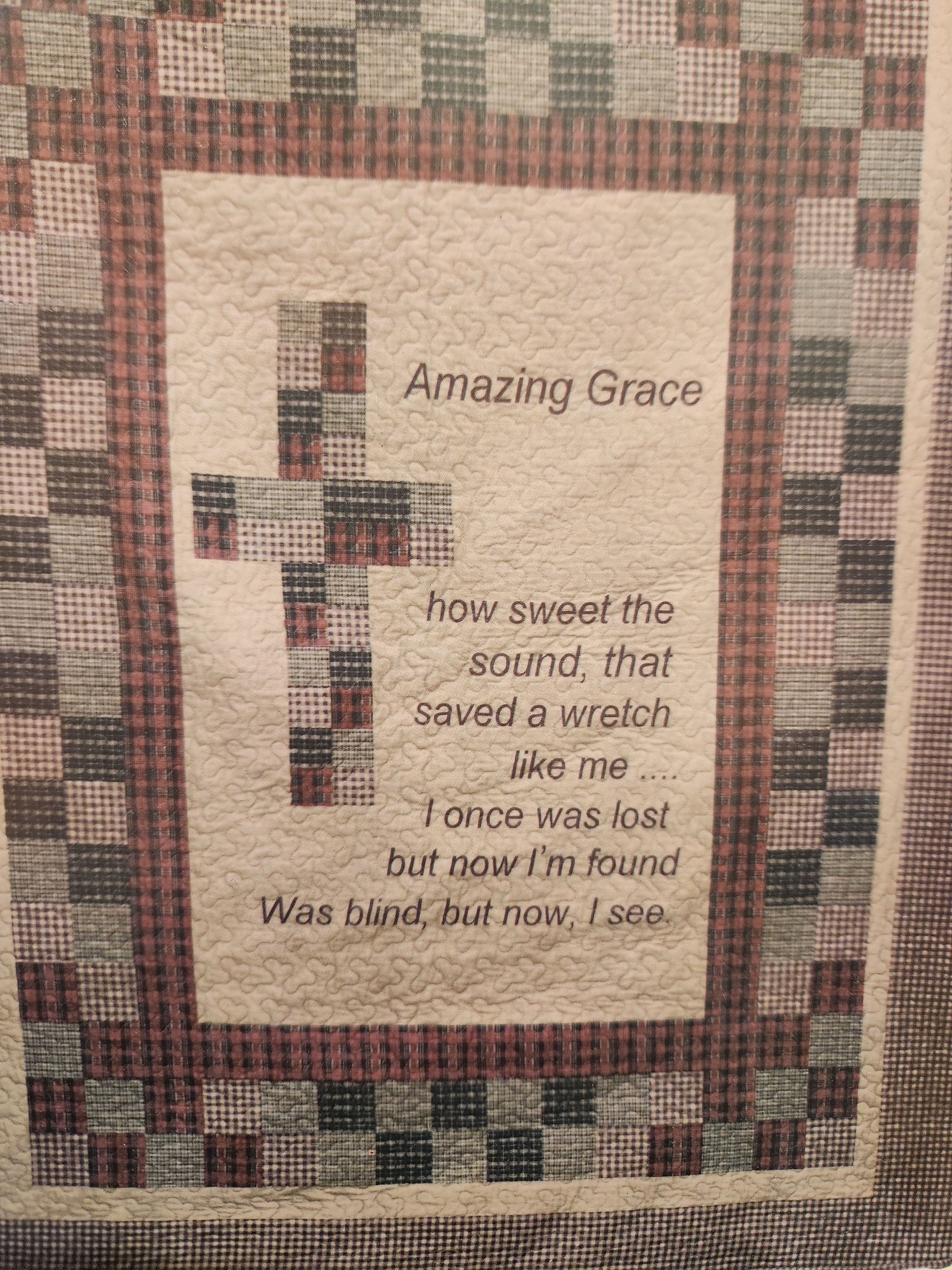 Quilted wall hanging with a cross and the words "Amazing Grace"