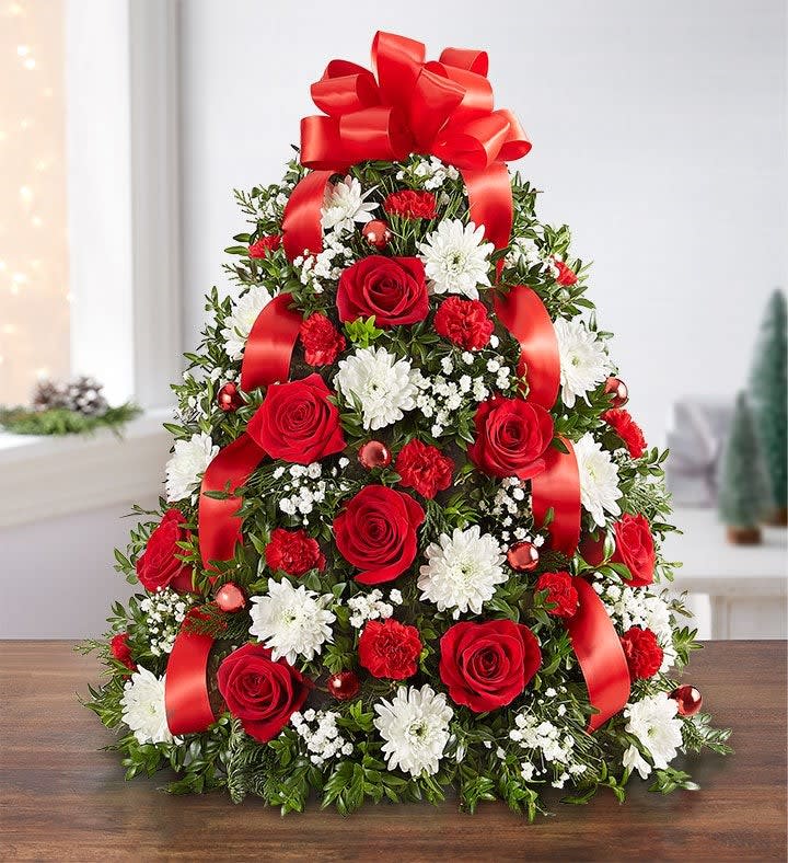 Tree-shaped floral arrangement with red roses, white daisies, and red ribbon bows