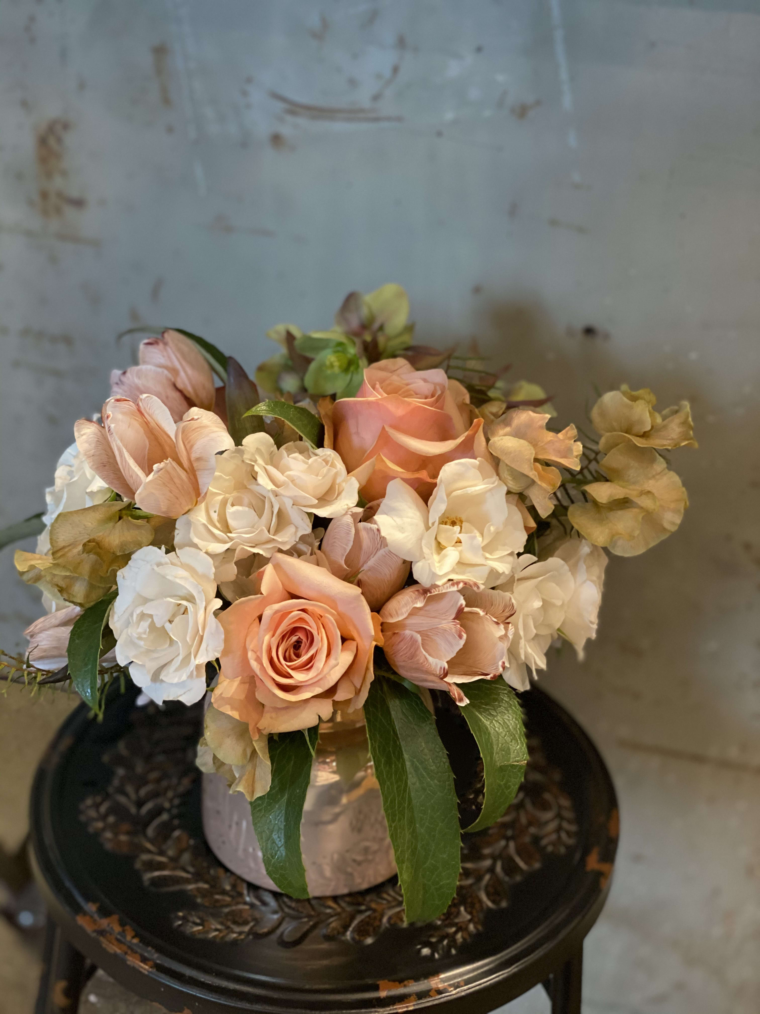 Peach and white roses arranged in a low vase