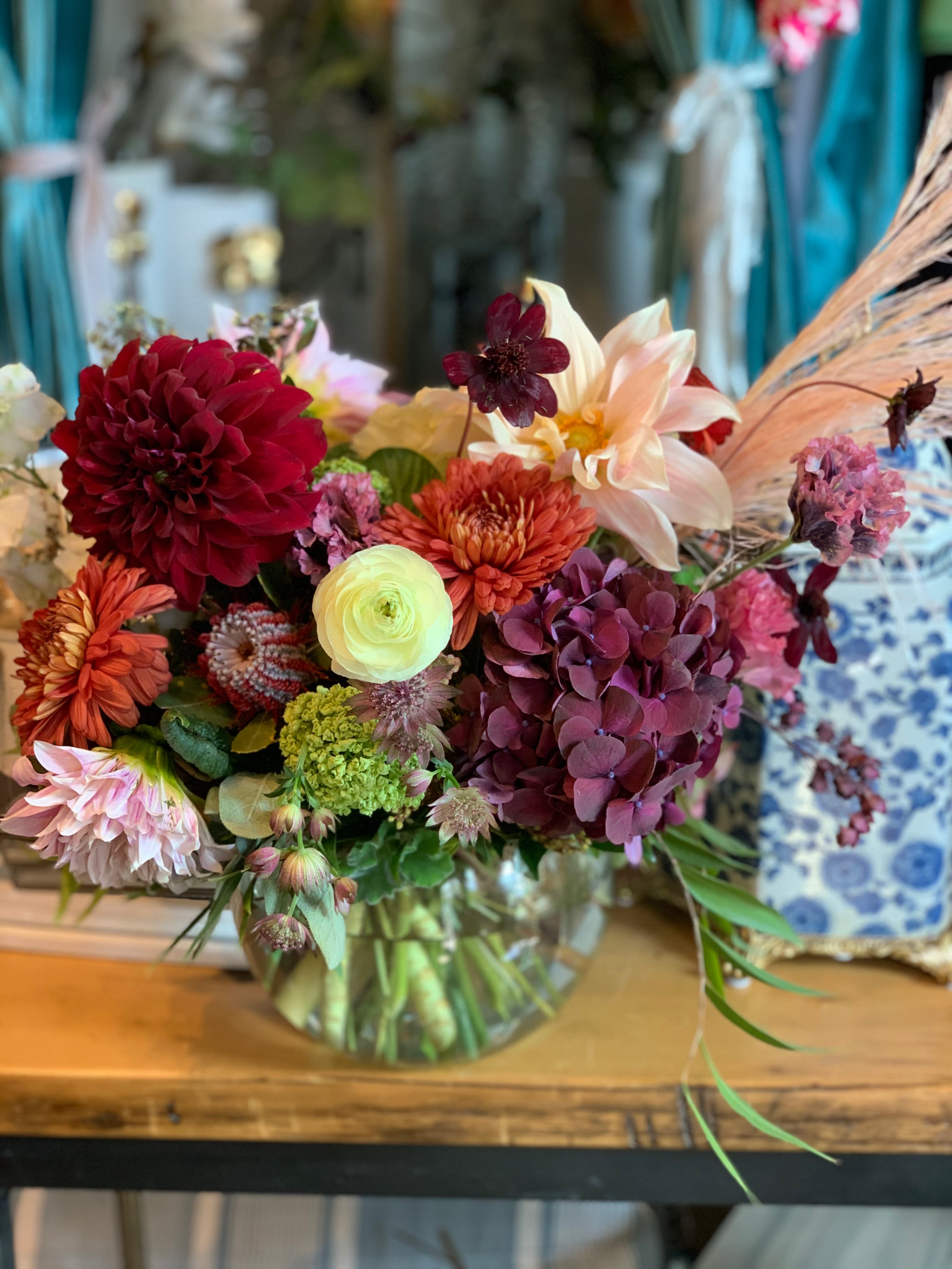 Mixed bouquet in a glass vase with burgundy, peach, and cream blooms