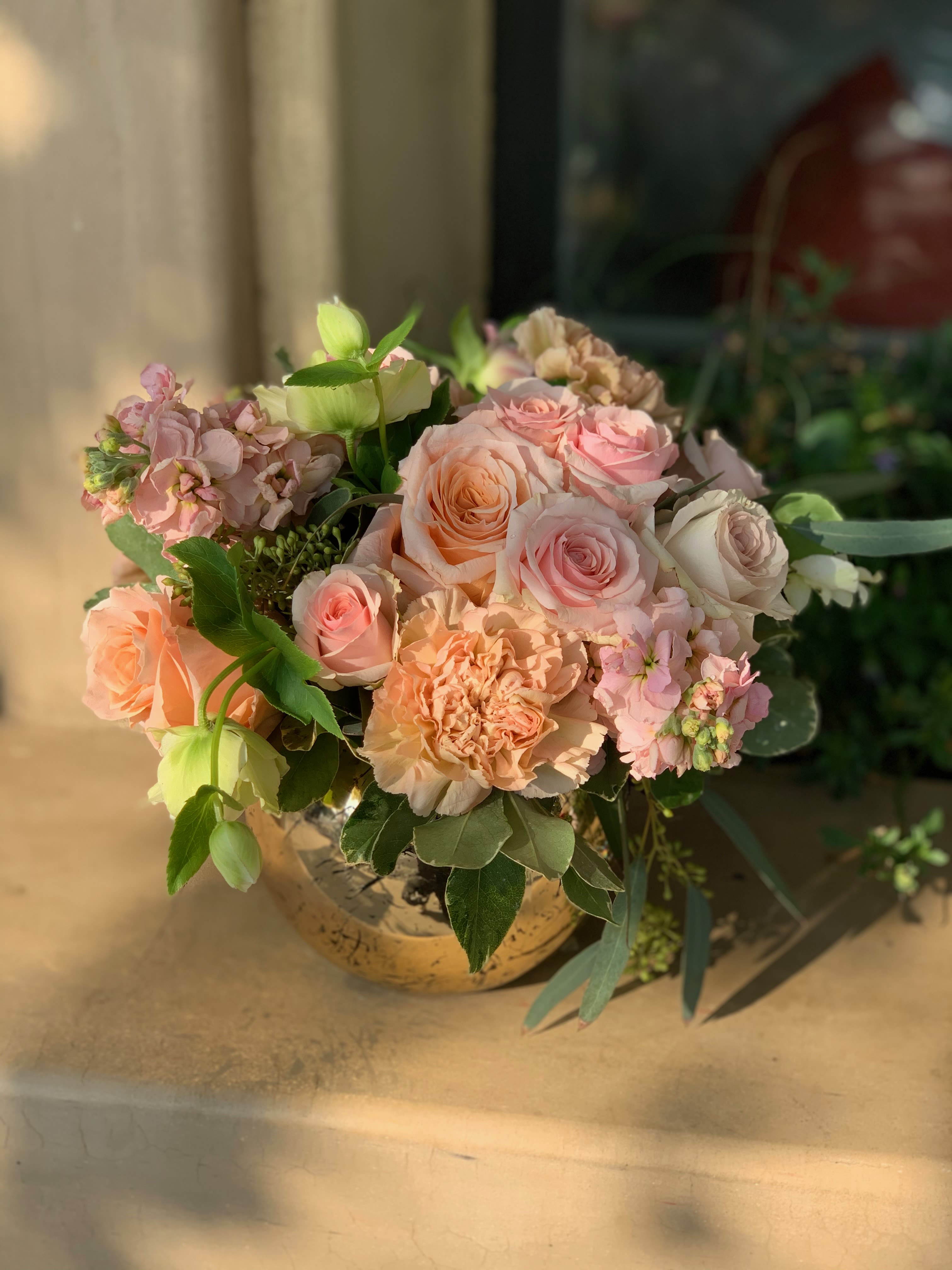 Peach and pink rose bouquet in a round vase