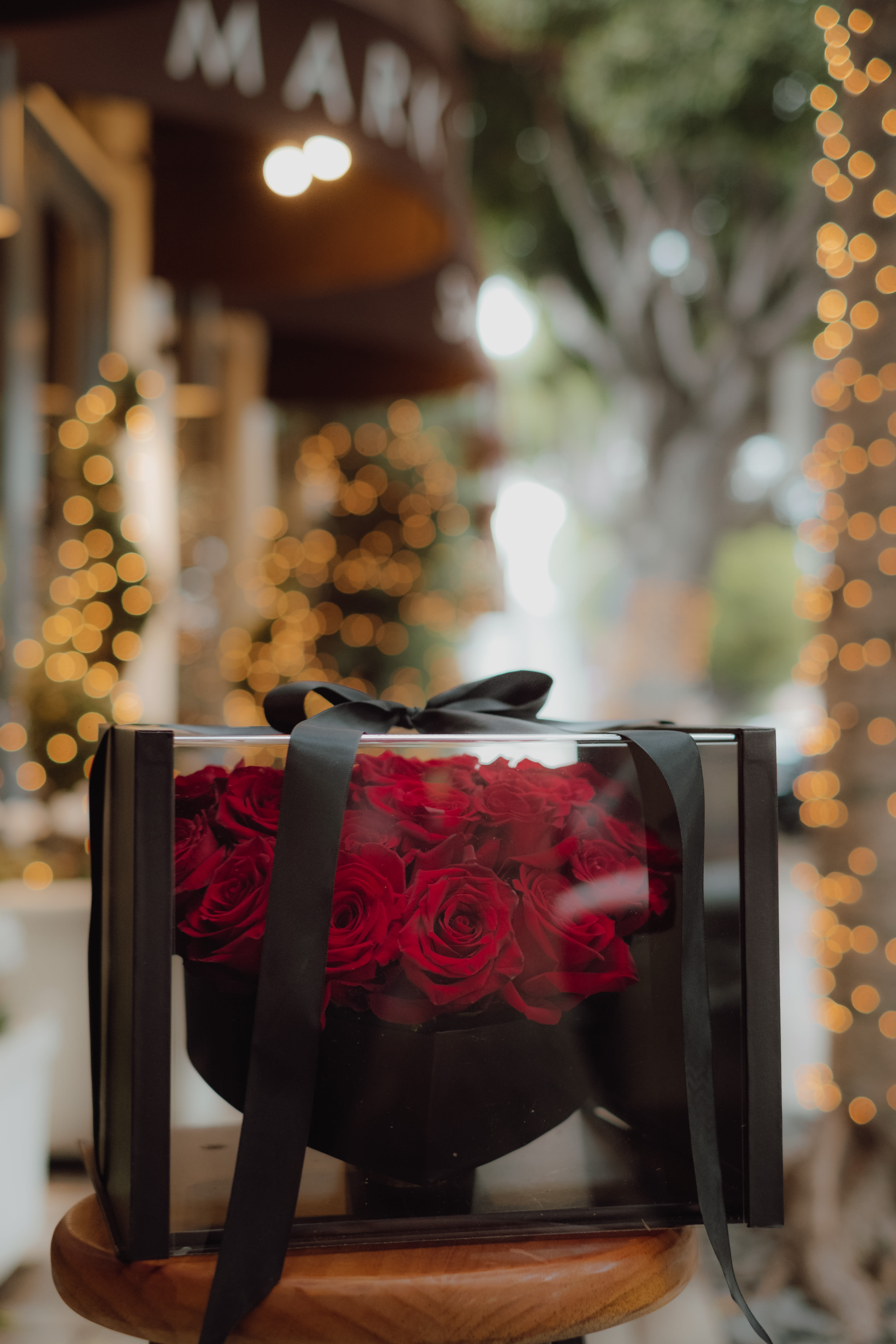 Box of red roses tied with a black ribbon