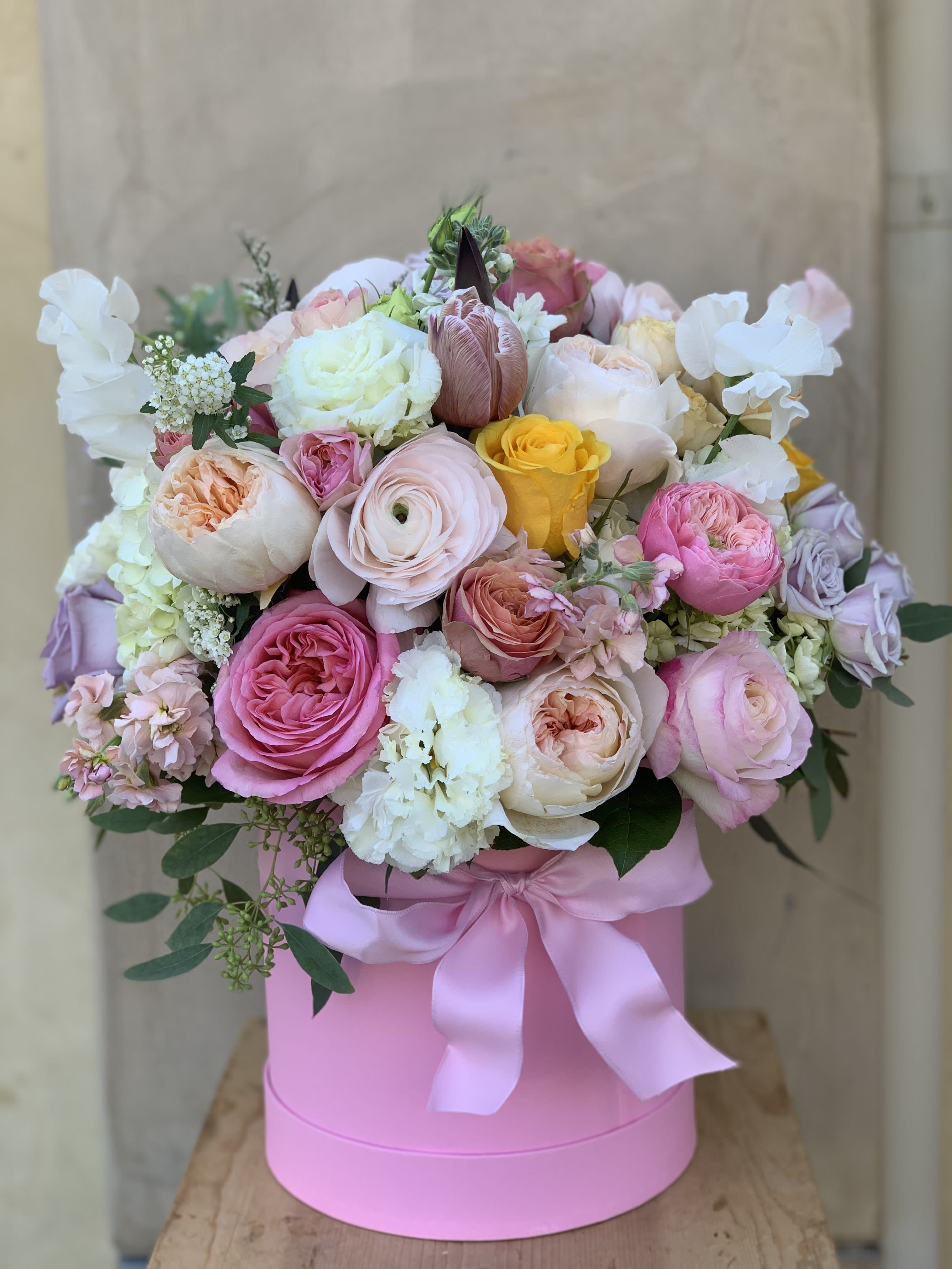 Pink and white rose bouquet in a pink hat box with a satin ribbon
