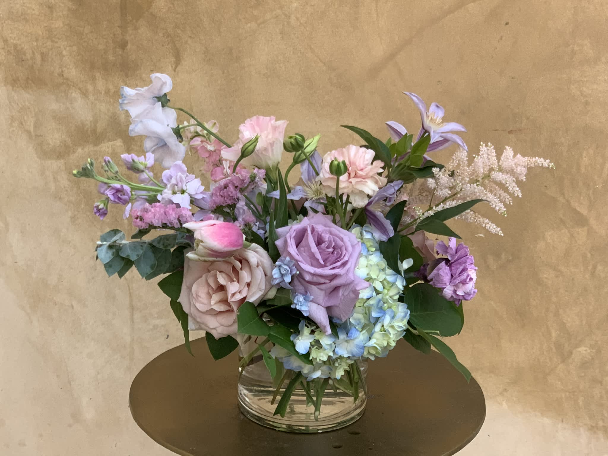 Pastel mixed flower arrangement in a clear glass vase