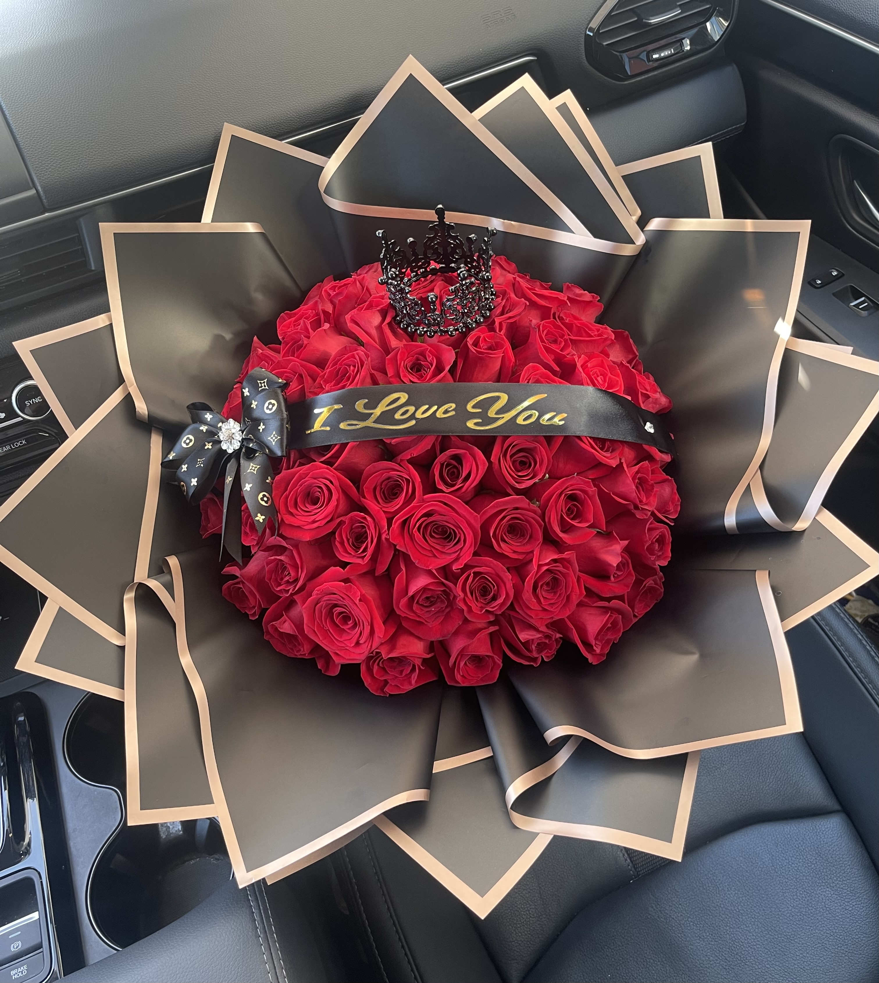 Bouquet of red roses wrapped in black paper with gold trim
