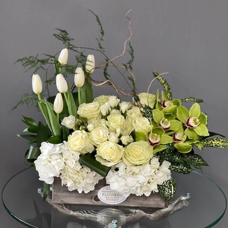 White tulips, roses, hydrangeas, and green orchids in a wooden box