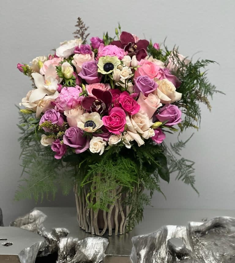 Bouquet of pink, purple, and white flowers in a woven vase