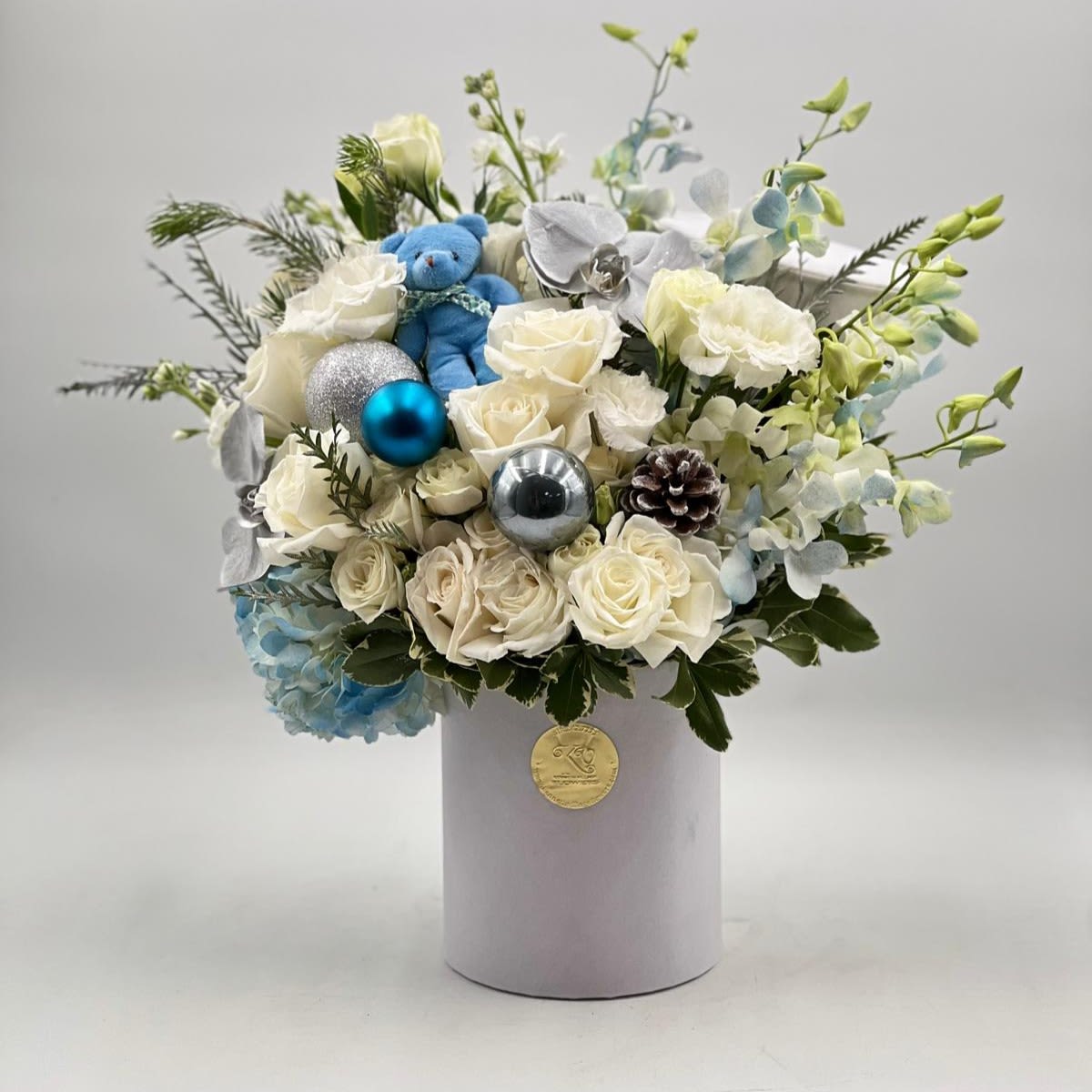 White rose bouquet with blue ornaments in a round box