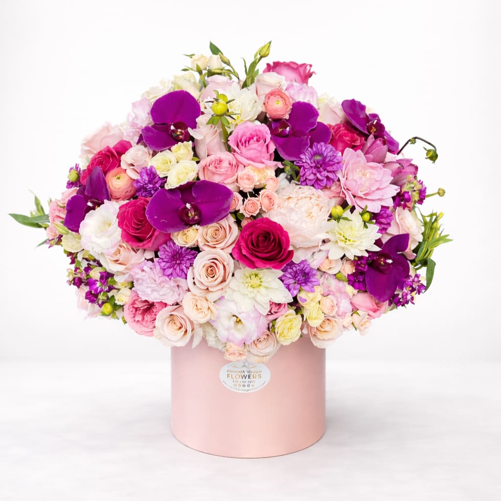 Large bouquet of pink, white, and purple flowers in a pink hat box