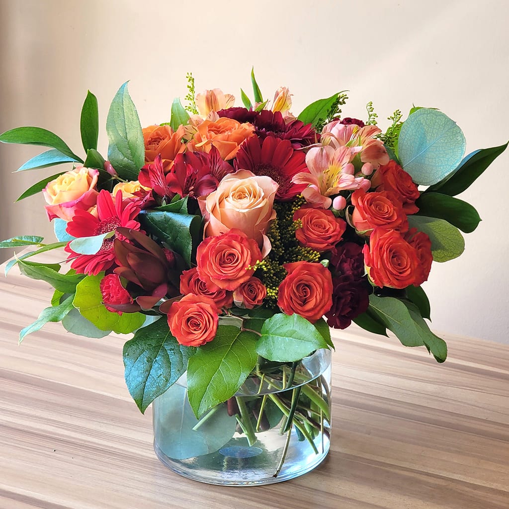 Mixed bouquet of roses, gerbera daisies, and alstroemeria in a glass vase