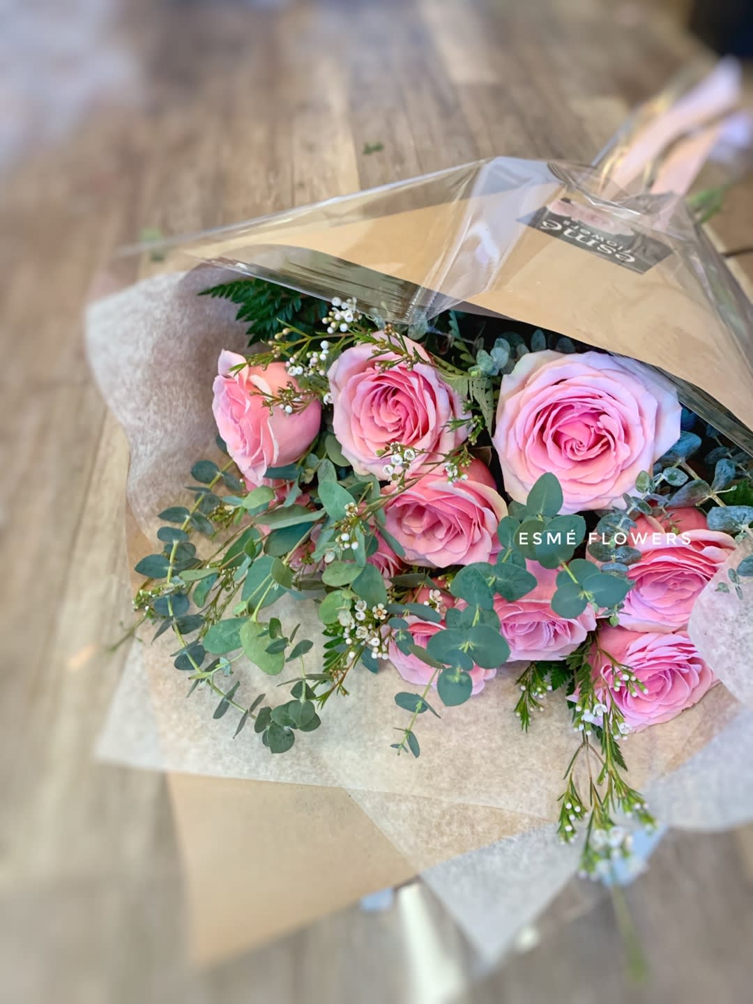 Bouquet of pink roses with eucalyptus in brown paper wrap