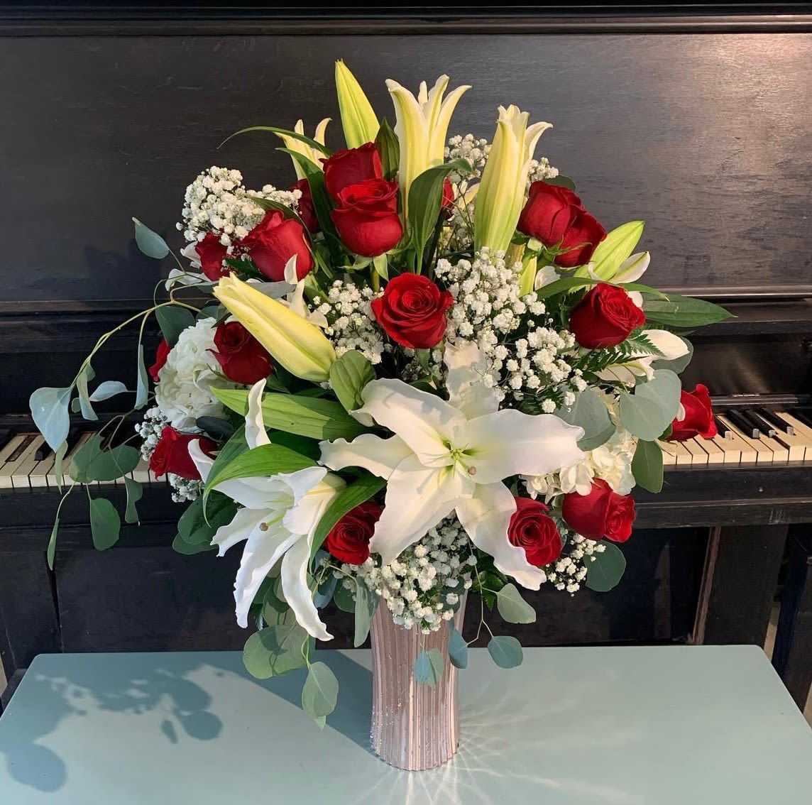 Red &amp; White Elegance  - Looking for more than just roses? Red &amp; White Elegance is the perfect way to go. This extra large arrangement is styled round and includes 18 red roses with touches of white lilies, babies breath, and hydrangeas. The bottom vase and florals are subject to change upon availability and arrangement will have an overall similar look to photo. 