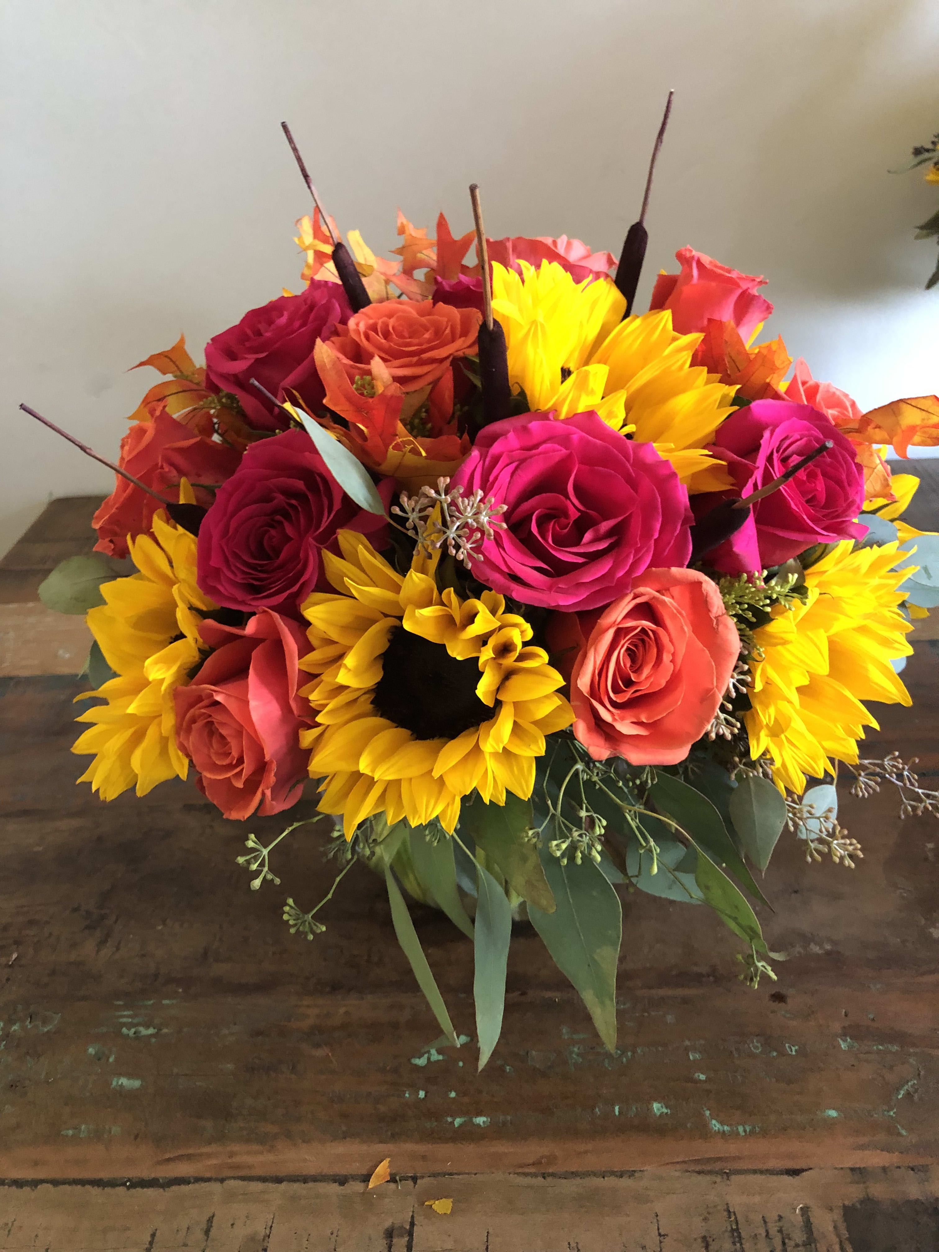 Bouquet of bright roses and sunflowers in a low arrangement