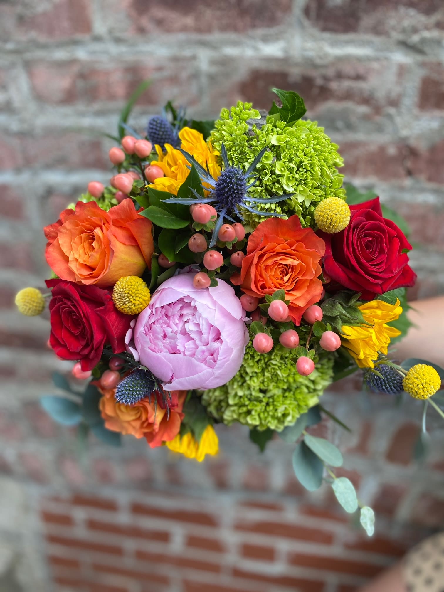 Colorful bouquet of roses, peonies, and green hydrangeas