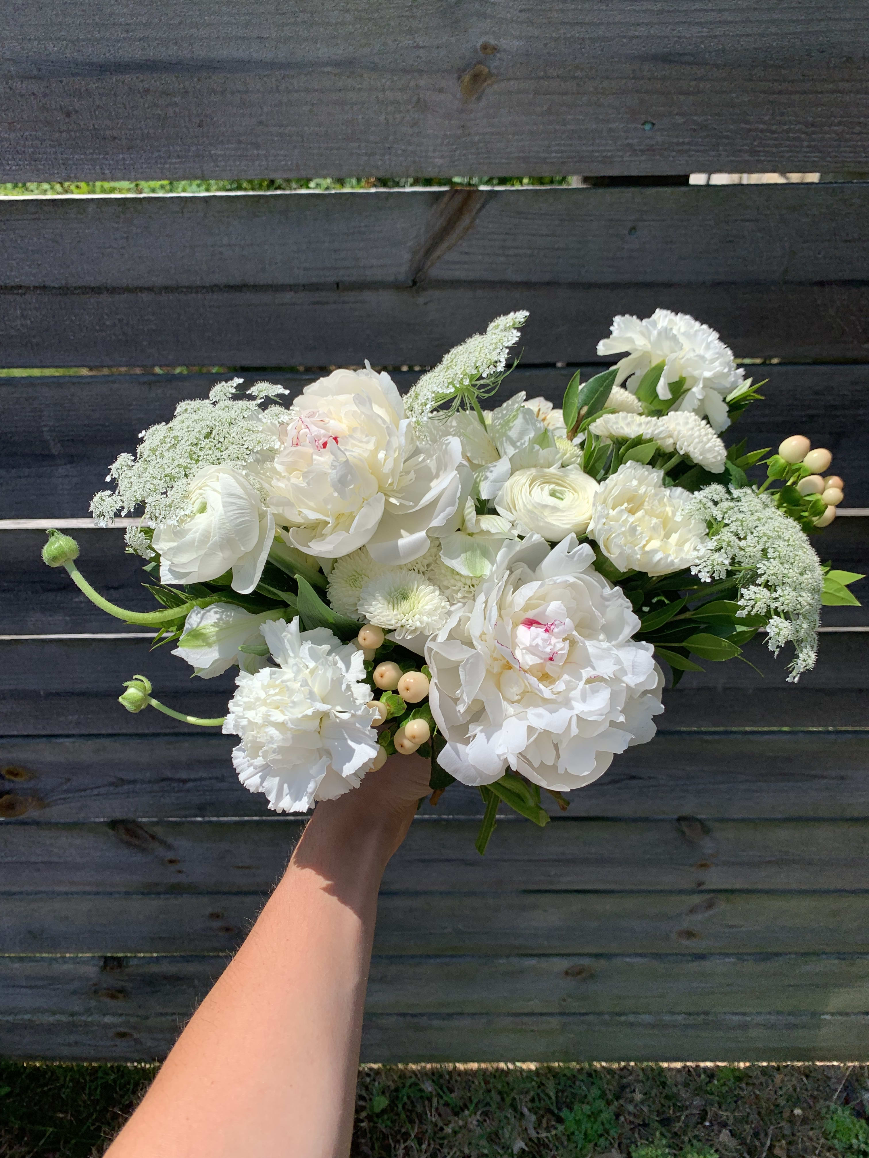 White bouquet of peonies, ranunculus, and carnations with laceflower accents