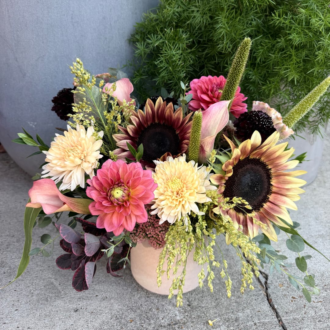 Mixed bouquet with sunflowers, pink dahlias, and calla lilies in a vase