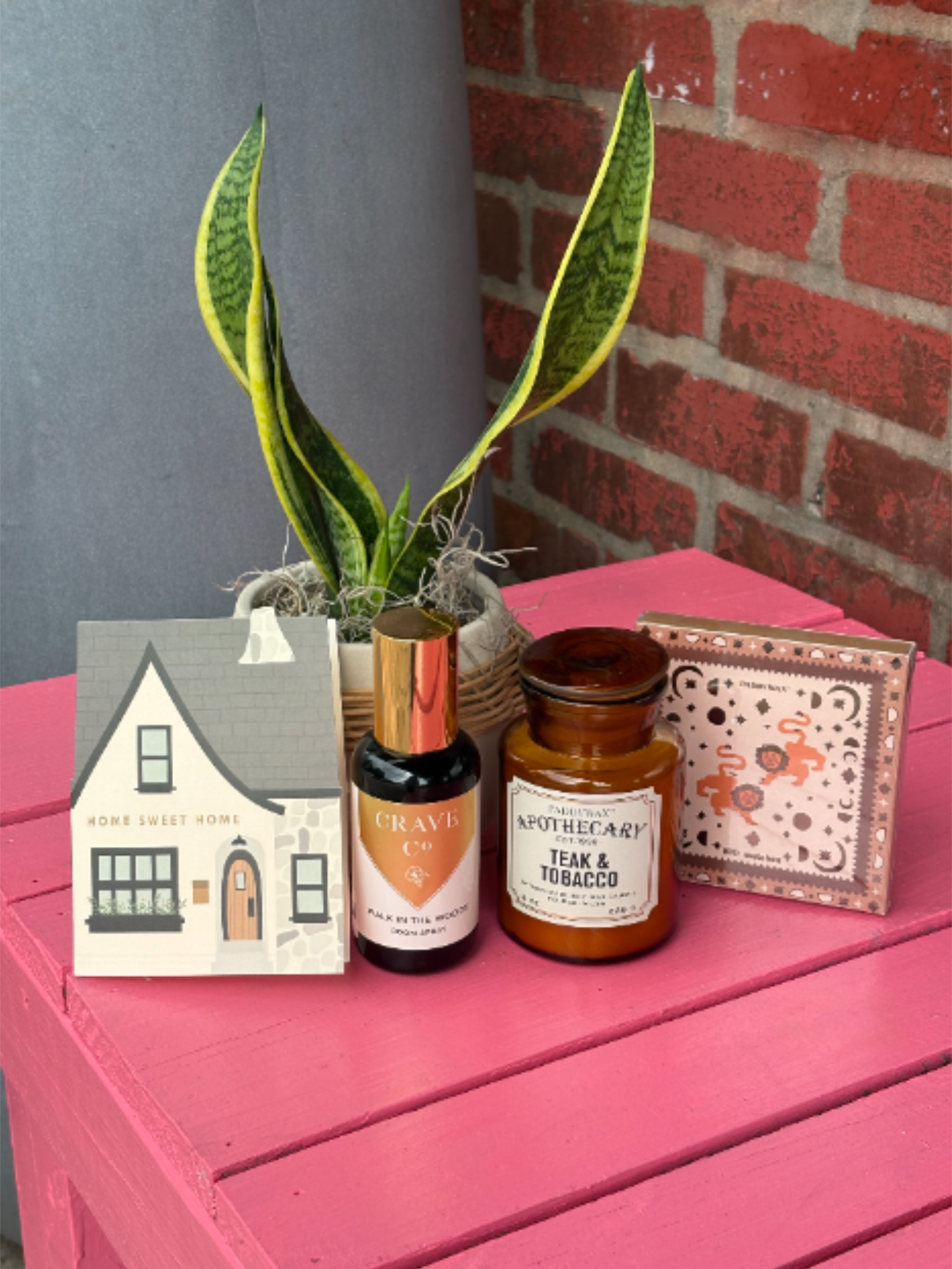 New Home Gift Set - Welcome them home with the perfect housewarming gift bundle! Featuring a sweet card, plant, candle, room spray, and matches, this thoughtful collection is designed to help them settle into their new home. Upgrade your order for a bigger plant or a larger candle.