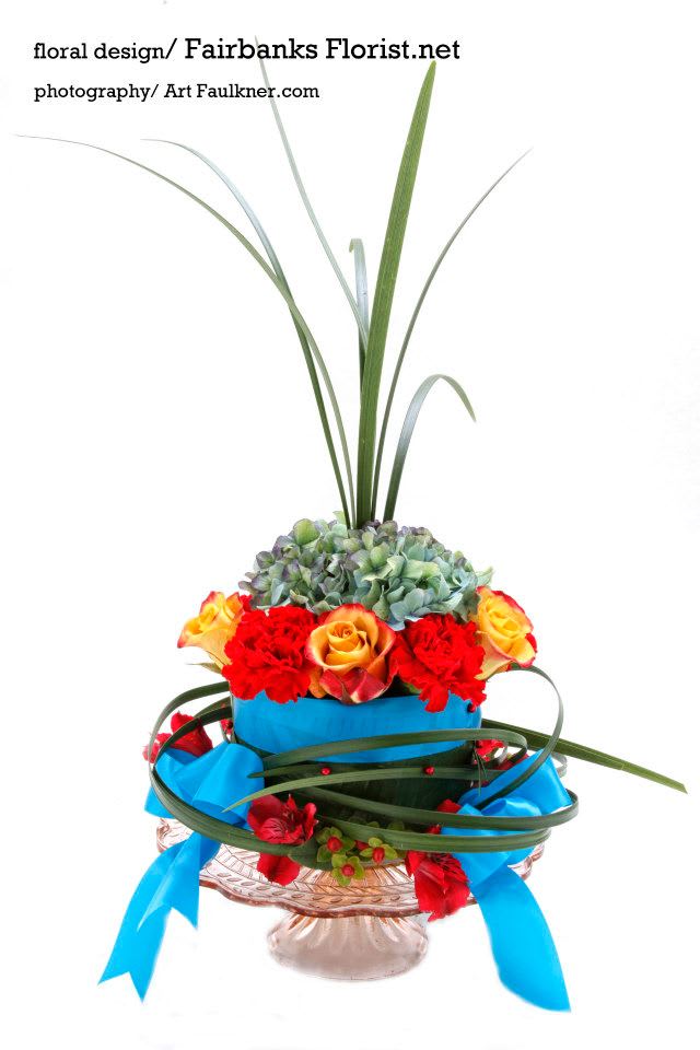 The Hannibal Square - Gorgeous floral birthday cake made custom by the owner of Fairbanks Florist, Lana Faulkner.   Our flowers are fresh in shop on the day of delivery. Your cake will be designed in the style shown but the flowers may be different from that pictured. We make every effort to use the best floral selection of the day.