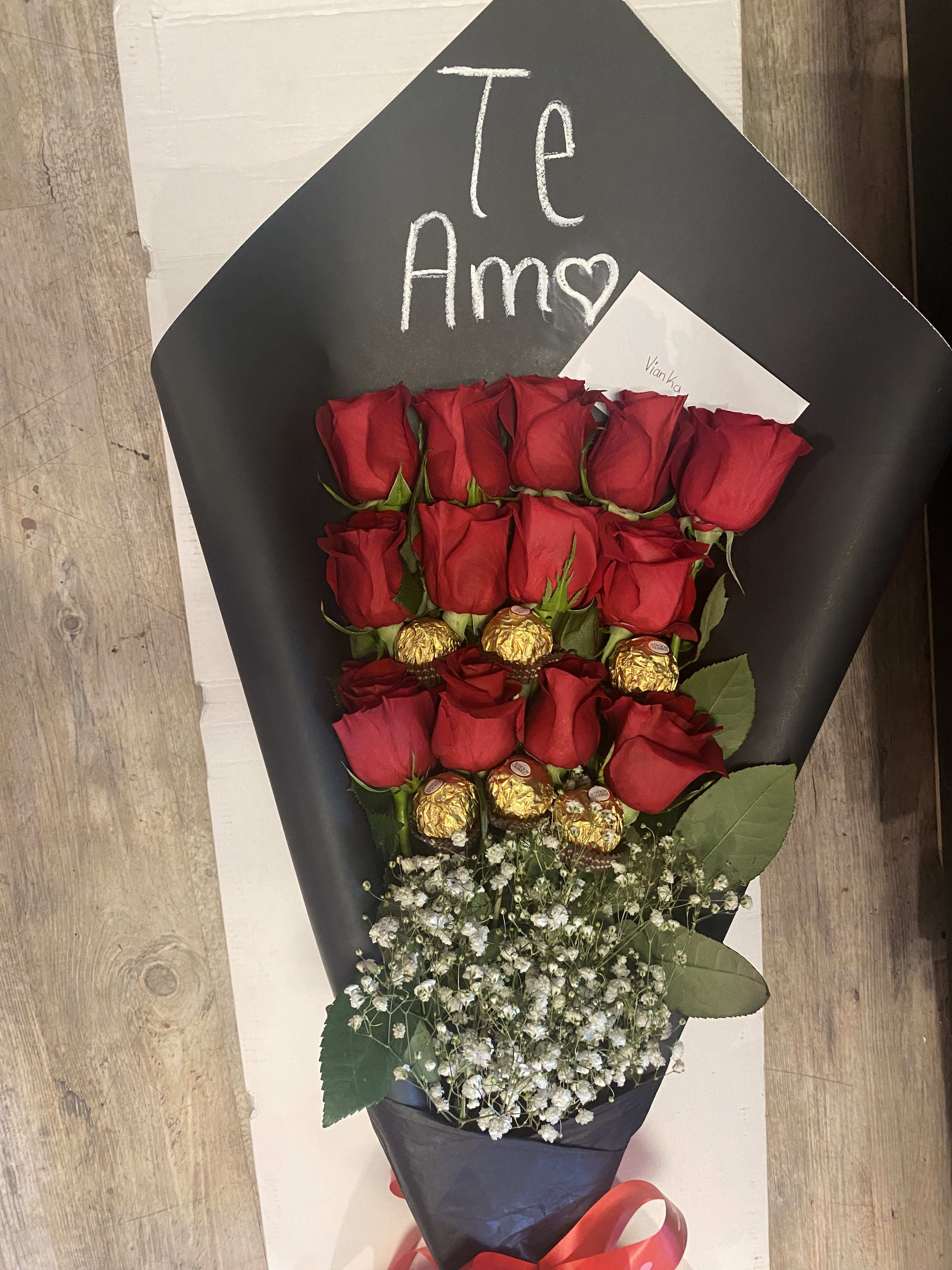 Bouquet of red roses with gold-wrapped chocolates and baby's breath