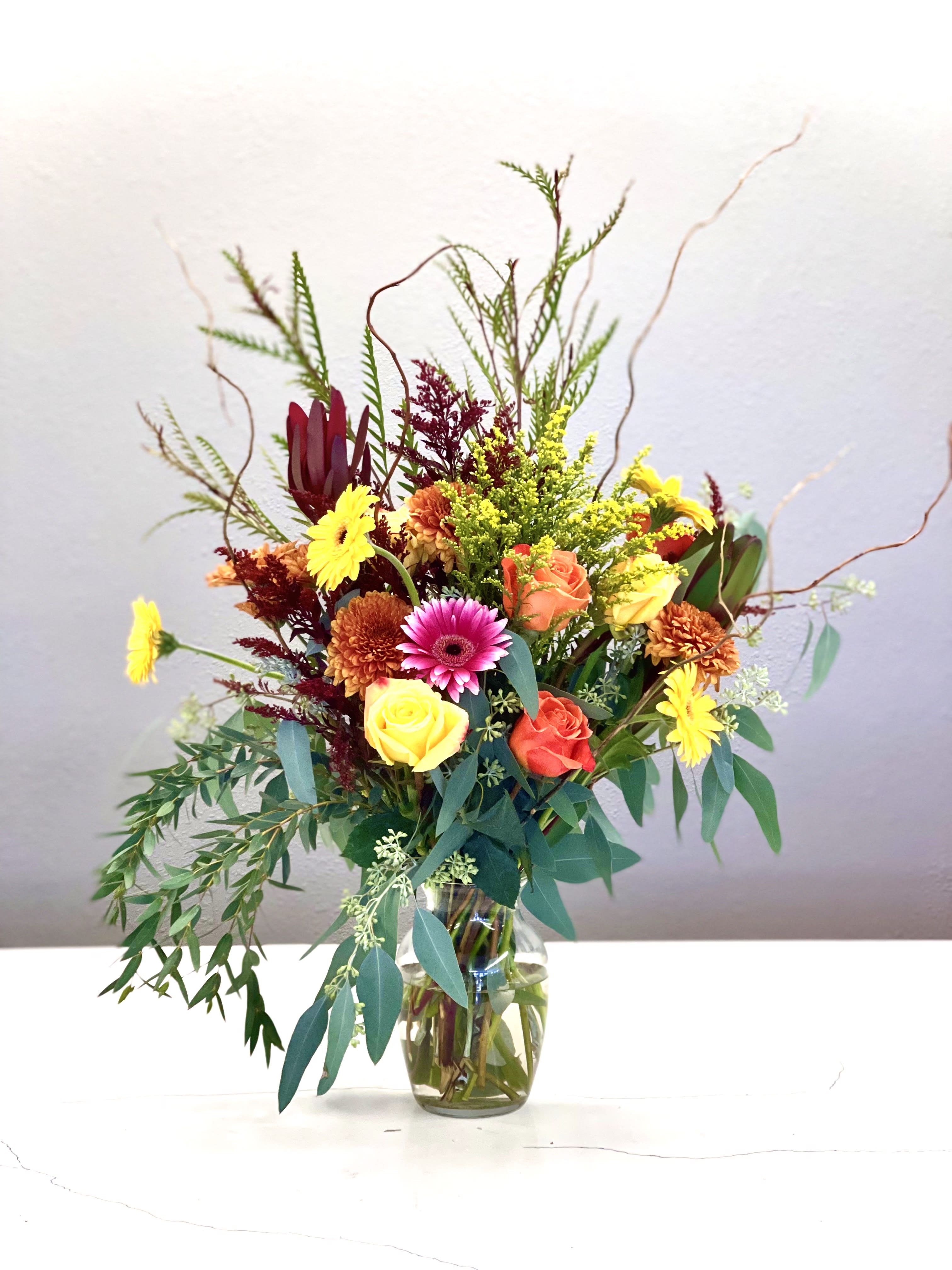 Mixed bouquet of roses and daisies in a glass vase