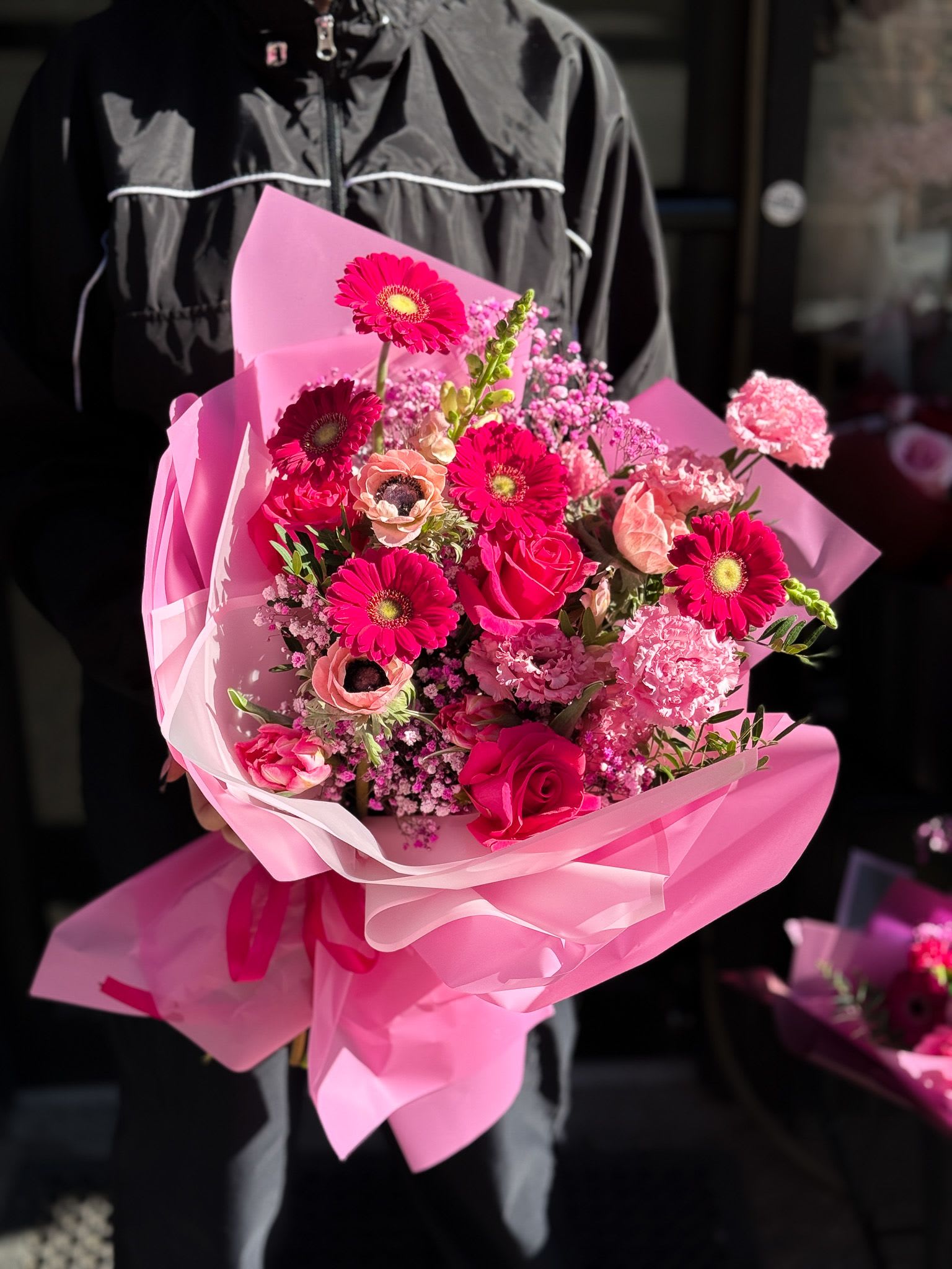 Pink bouquet with roses and gerbera daisies wrapped in pink paper