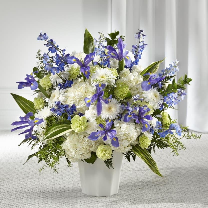 White and purple floral arrangement in a white vase