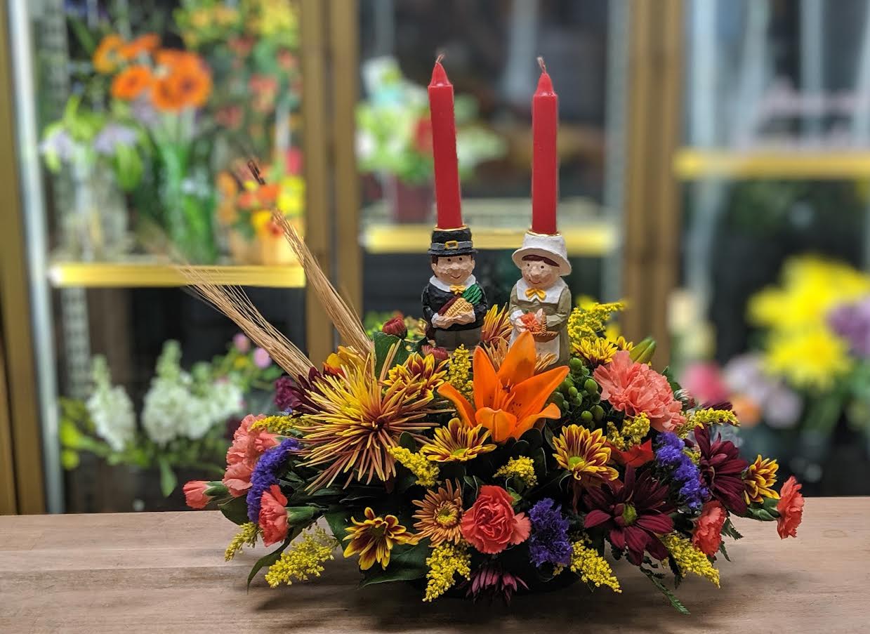 Festive Fall Centerpiece (Designer Choice) - If you're still having a Socially Distance Thanksgiving, you could invite this couple over for dinner. This seasonal centerpiece displays all the feelings of fall. Please note this a designer choice arrangement. If you have any specifications please add in the special instructions or call us at the shop. If you do not want the candles in due to safety concerns please let us know. Approx. 17Wx15H All Around