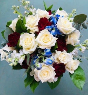 Bouquet of white roses, red carnations, and blue flowers