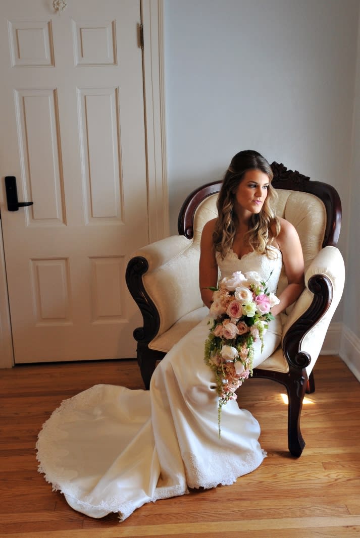 Bride in a white gown holding a cascading bouquet of pink and white flowers