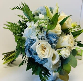 Bouquet of white roses, blue flowers, and lilies with greenery