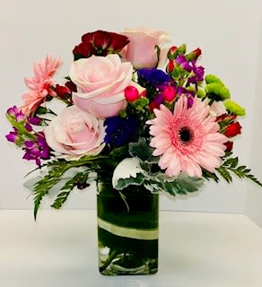 Mixed bouquet with pink roses and gerbera daisies in a glass vase