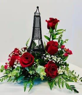Red roses arranged around a small Eiffel Tower decoration