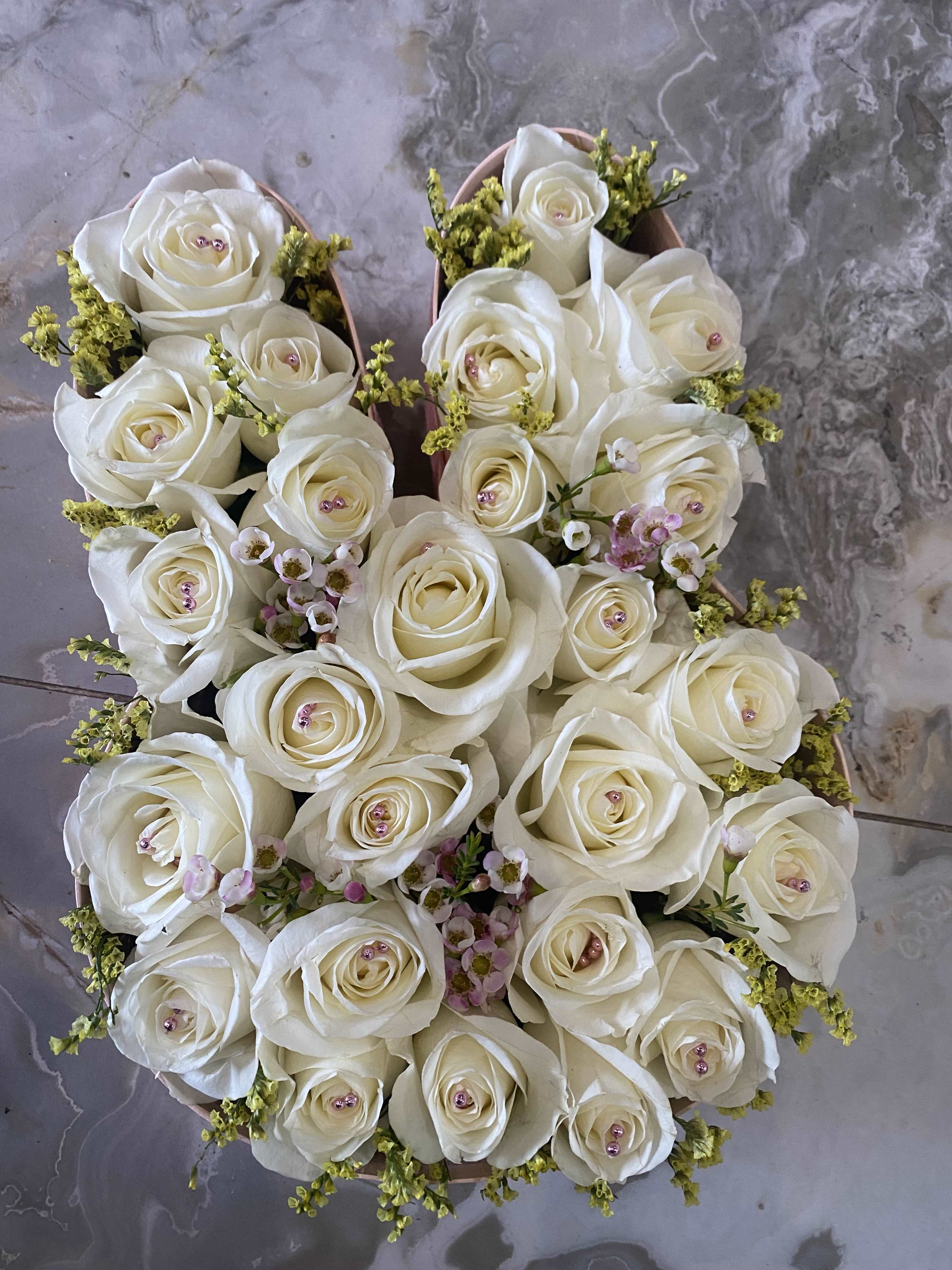 Round bouquet of white roses with small pink filler flowers