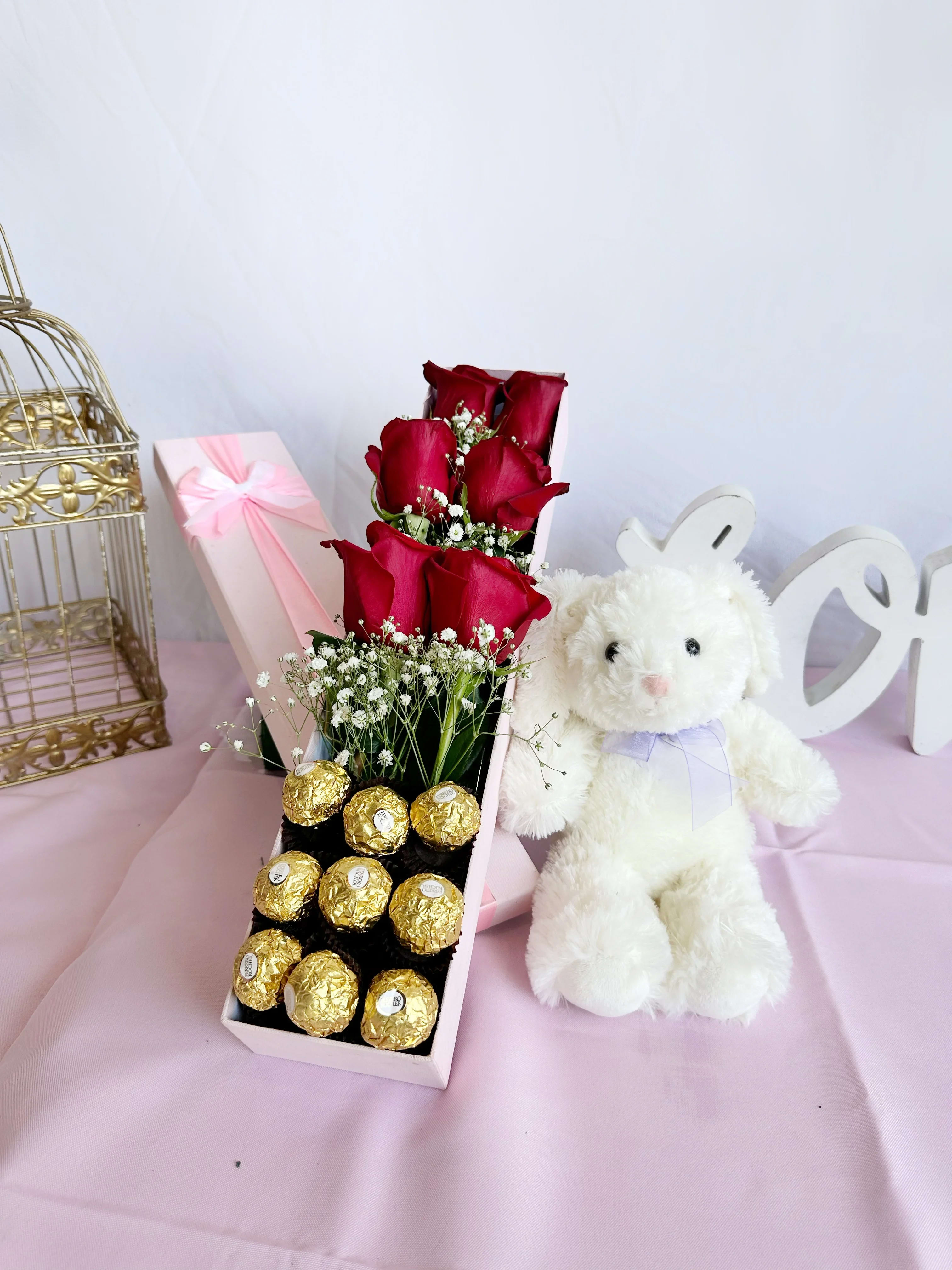 Red roses in a gift box with chocolates and a white teddy bear