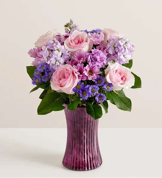 Daydream Bouquet - Just like a daydream. Our delightful lavender bouquet is gathered with accents of pink and lush greenery in our striking fluted violet gathering vase. Designed in vintage pressed glass with ribbed detailing, it captures the rich beauty of the blooms, along with the thoughtfulness of your sentiment.
