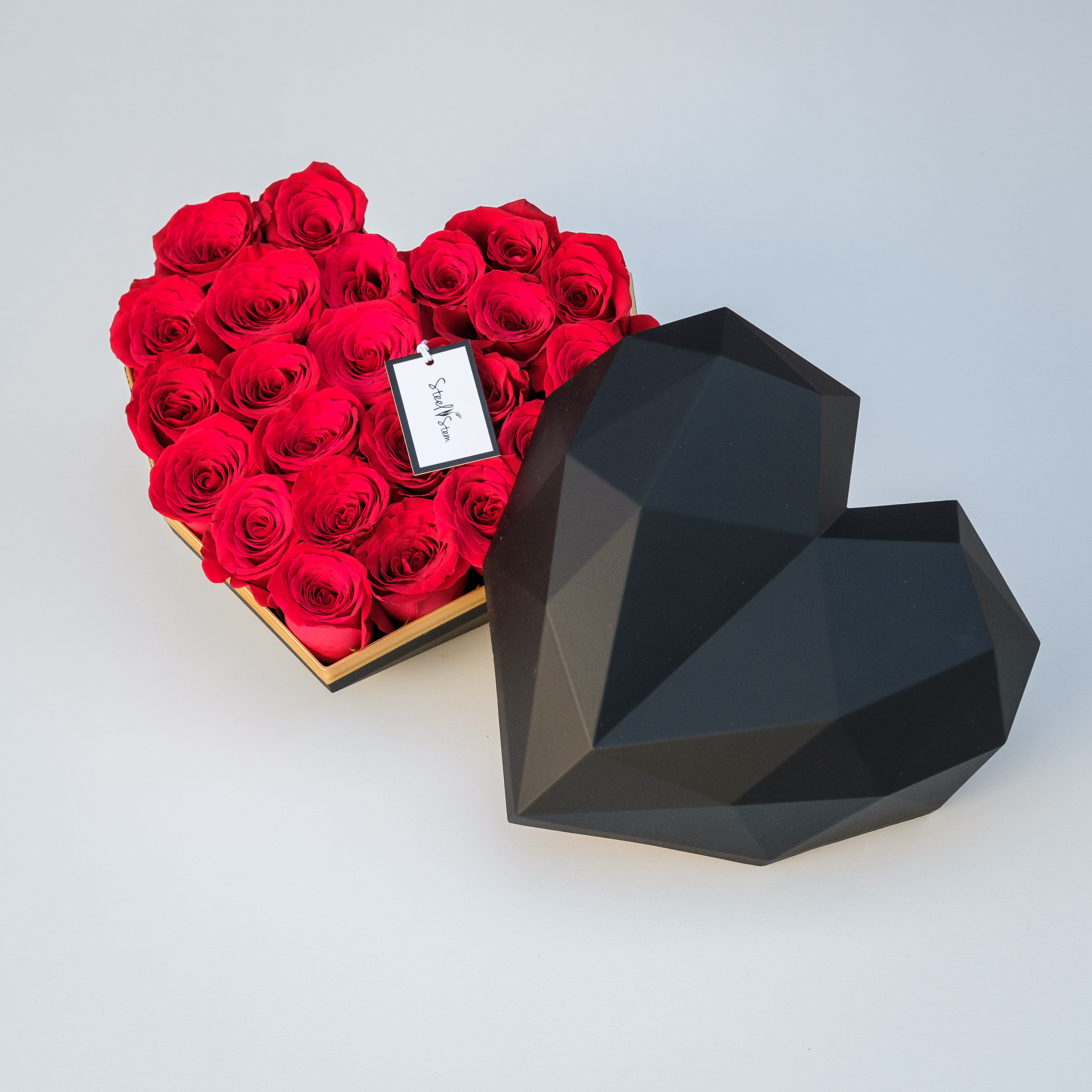 My Heart Gift Box - This item is only available in gray or white. Our large geometric heart shaped gift box is packed full of gorgeous premium classic red roses and is tightly wrapped with our signature Steel Stem ribbon.  Choose this gift to send your love in the most romantic way possible and really treat that special someone to a luxury gift they'll never forget! This box is reusable and can be easily be repurposed for home decor or to refill with more flowers!   Approximately 10" L x 10" W x 7"D.