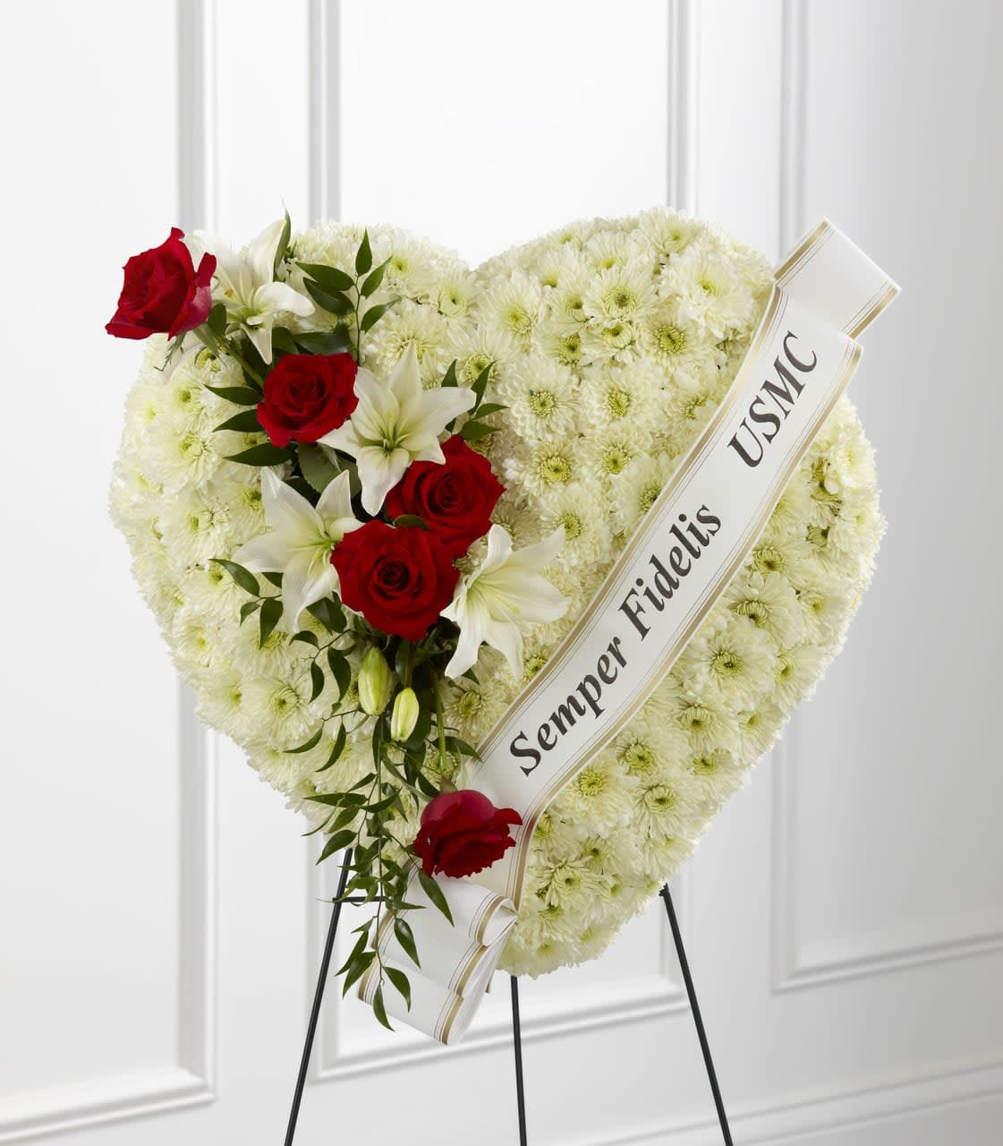 TLSP The Salute to a Patriot Standing Heart - The Salute to a Patriot Standing Heart is the perfect tribute to a fallen marine. A pearly white heart consisting of chrysanthemums is accented with an arrangement of red roses, white Asiatic lilies and lush greens, as well as a white banner that reads, "Semper Fidelis USMC", to create an incredible presentation at their final memorial service. Displayed on a wire easel. Approximately 24"H x 24"W.  Your purchase includes a complimentary personalized gift message.