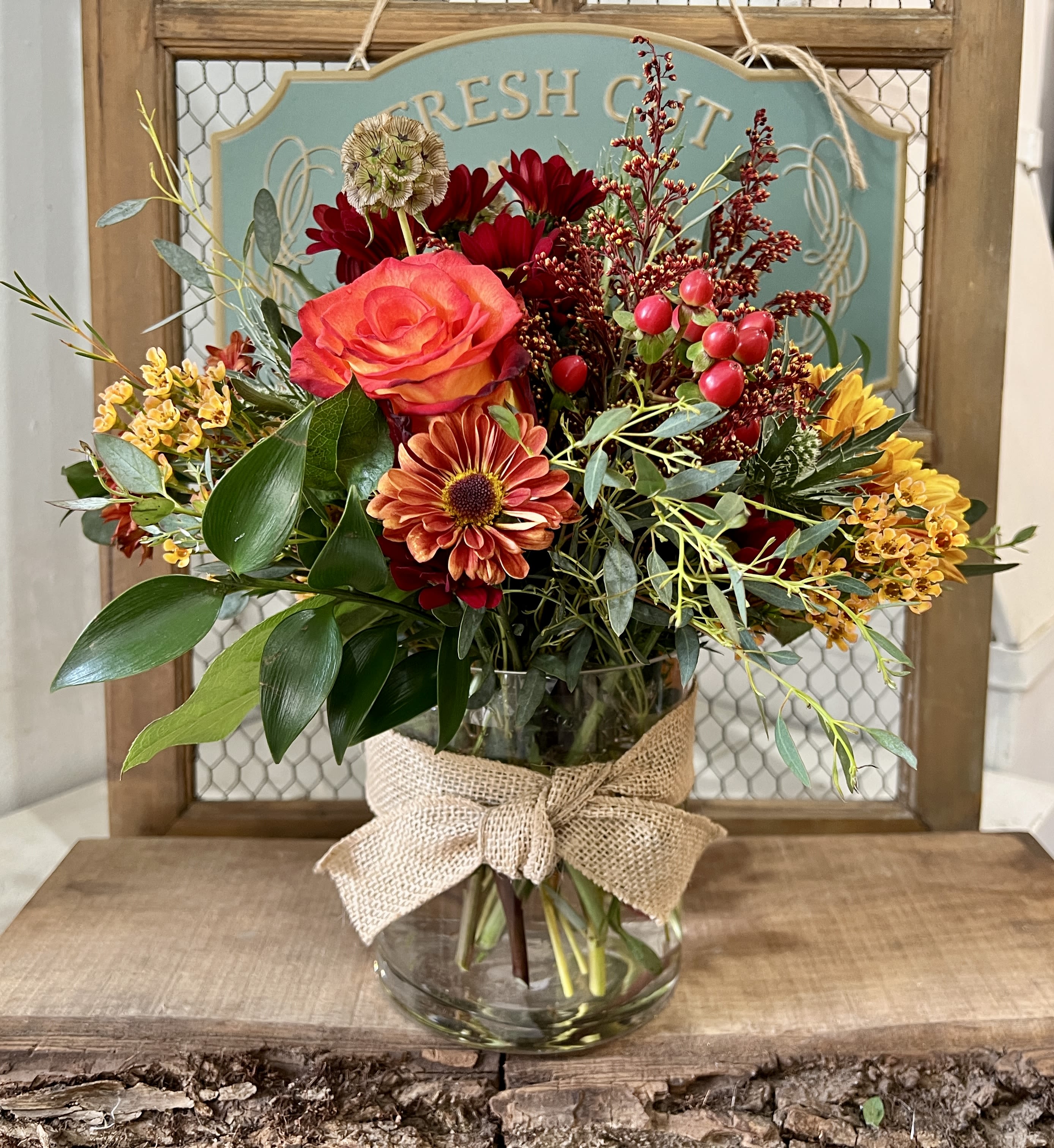 Mixed bouquet in a glass vase with a burlap bow