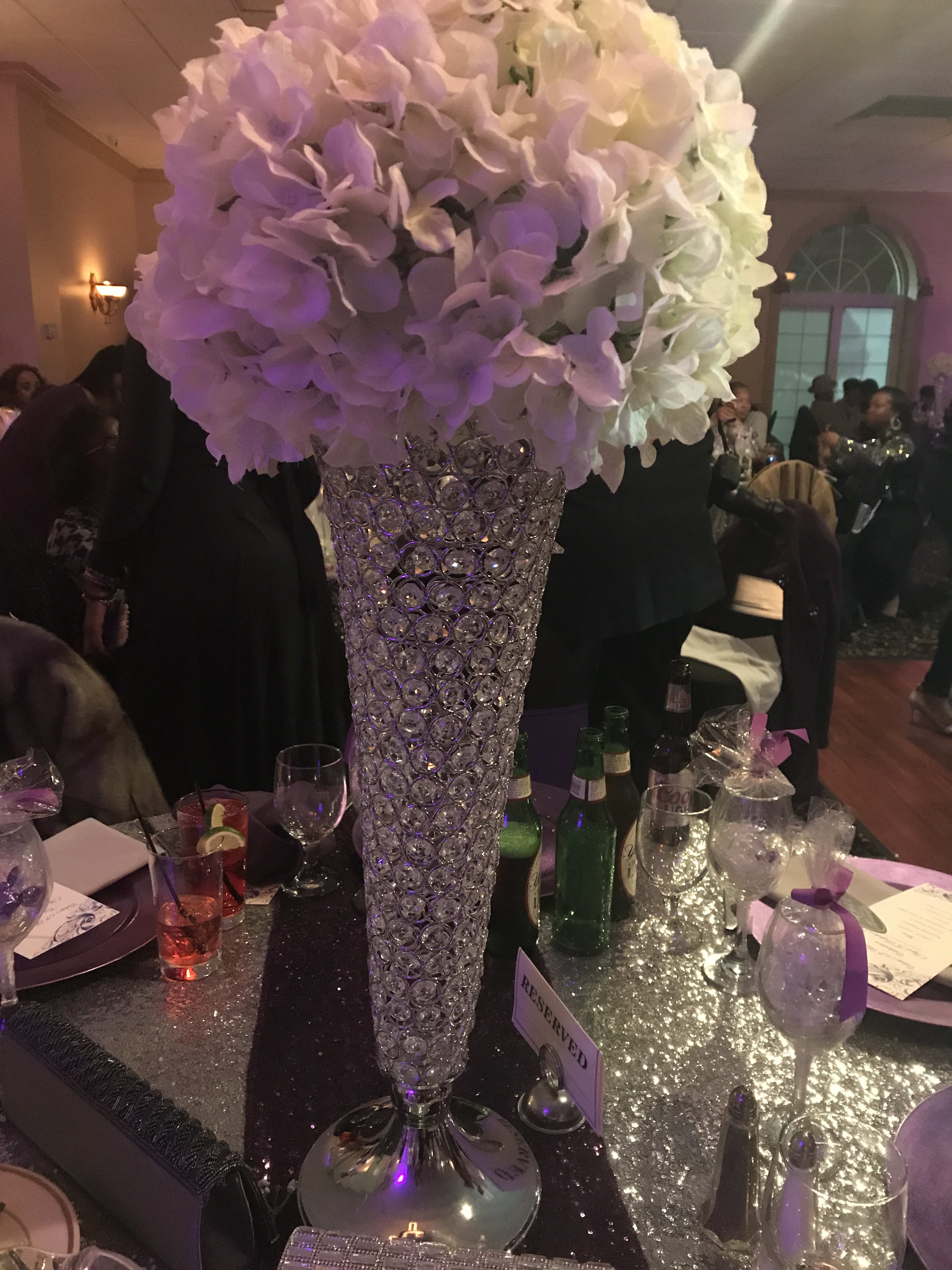 Tall white and lavender floral centerpiece in a crystal vase
