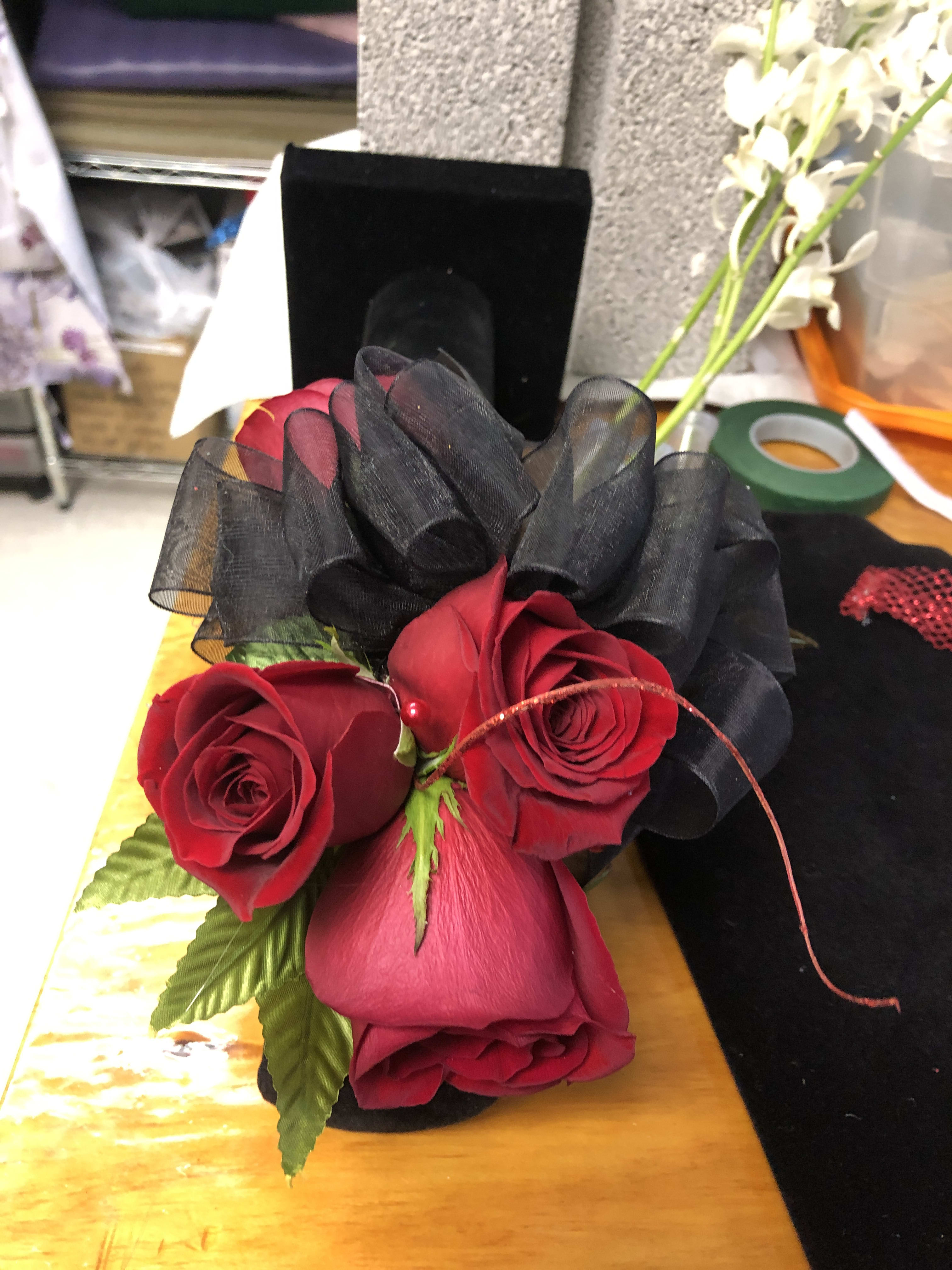 Red roses with black ribbon in a small bouquet