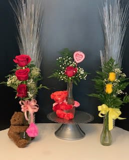 Three rose arrangements with teddy bears and ribbons